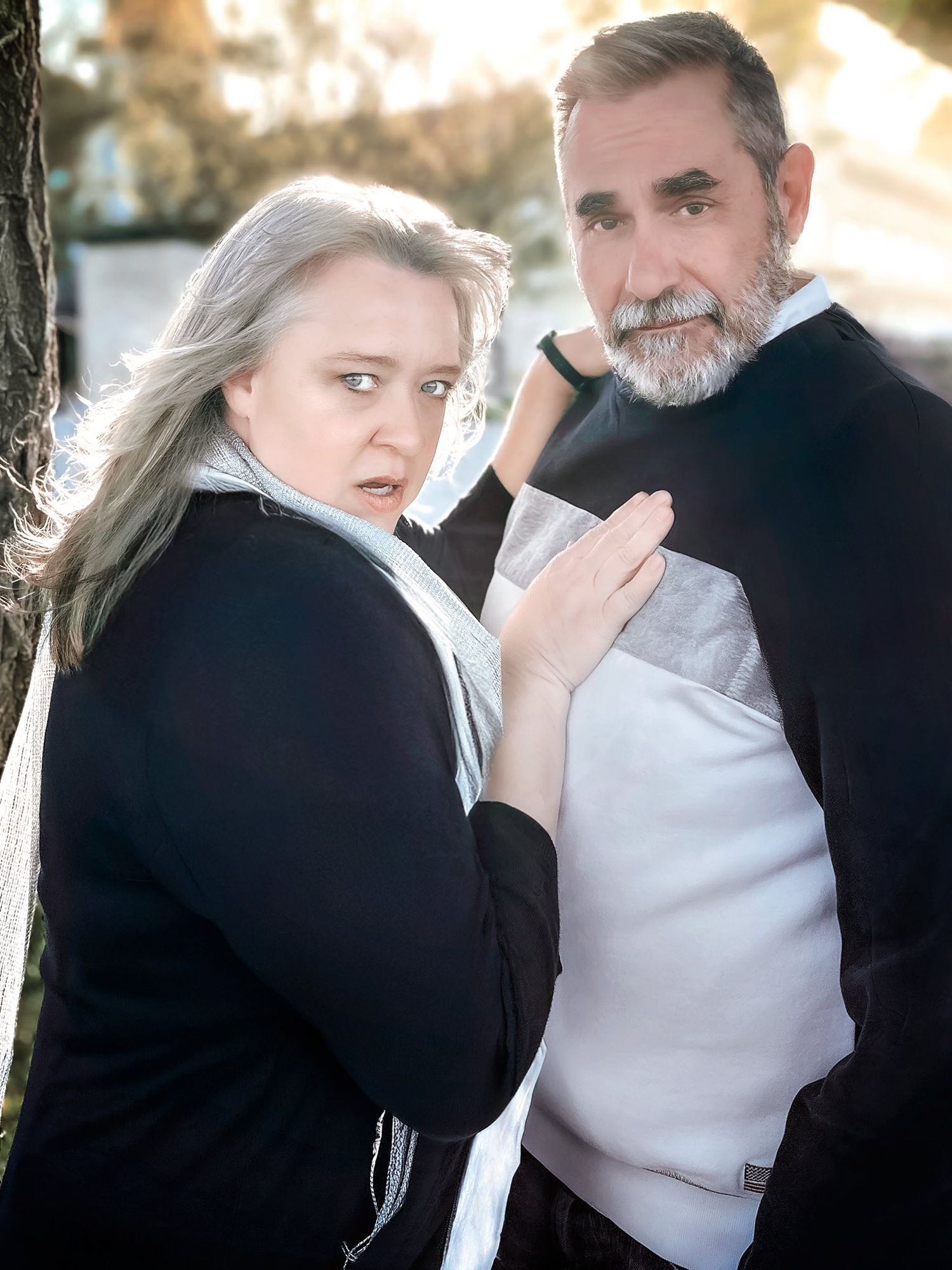 Couple in black and white attire share romantic moments during a sunset photoshoot.