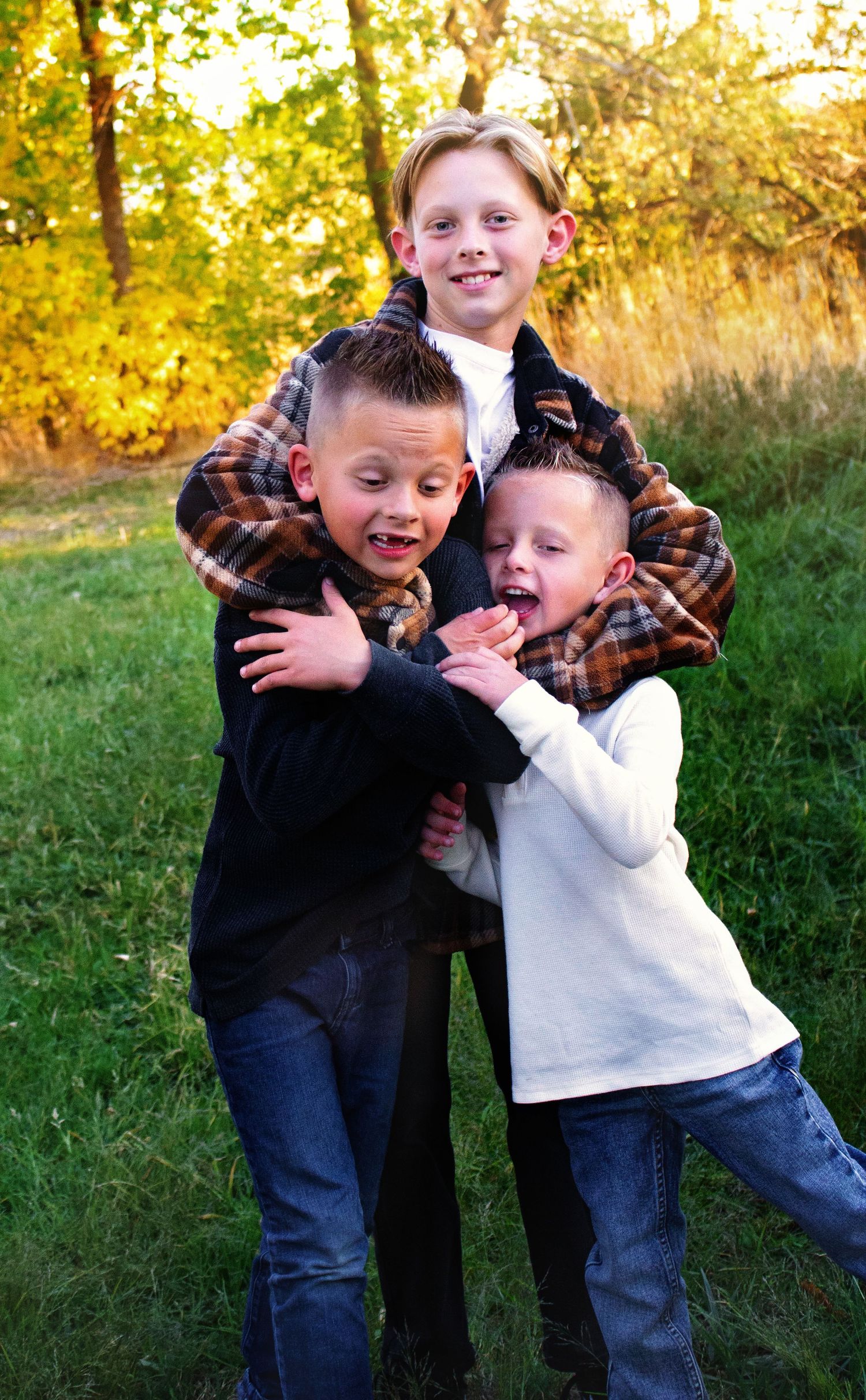 Playful candid moments captured during outdoor family photoshoot in grass field.