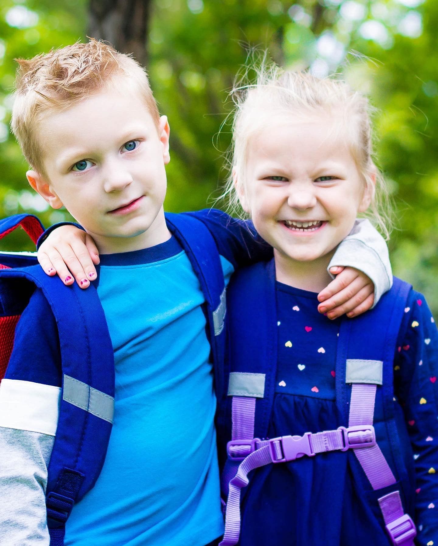 Children wearing blue outfits playing together outdoors.
