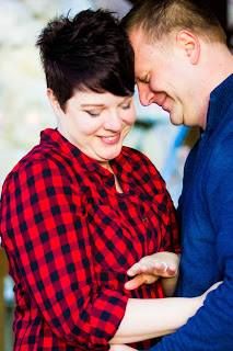 Couple in red plaid and blue sharing playful moments during engagement shoot.