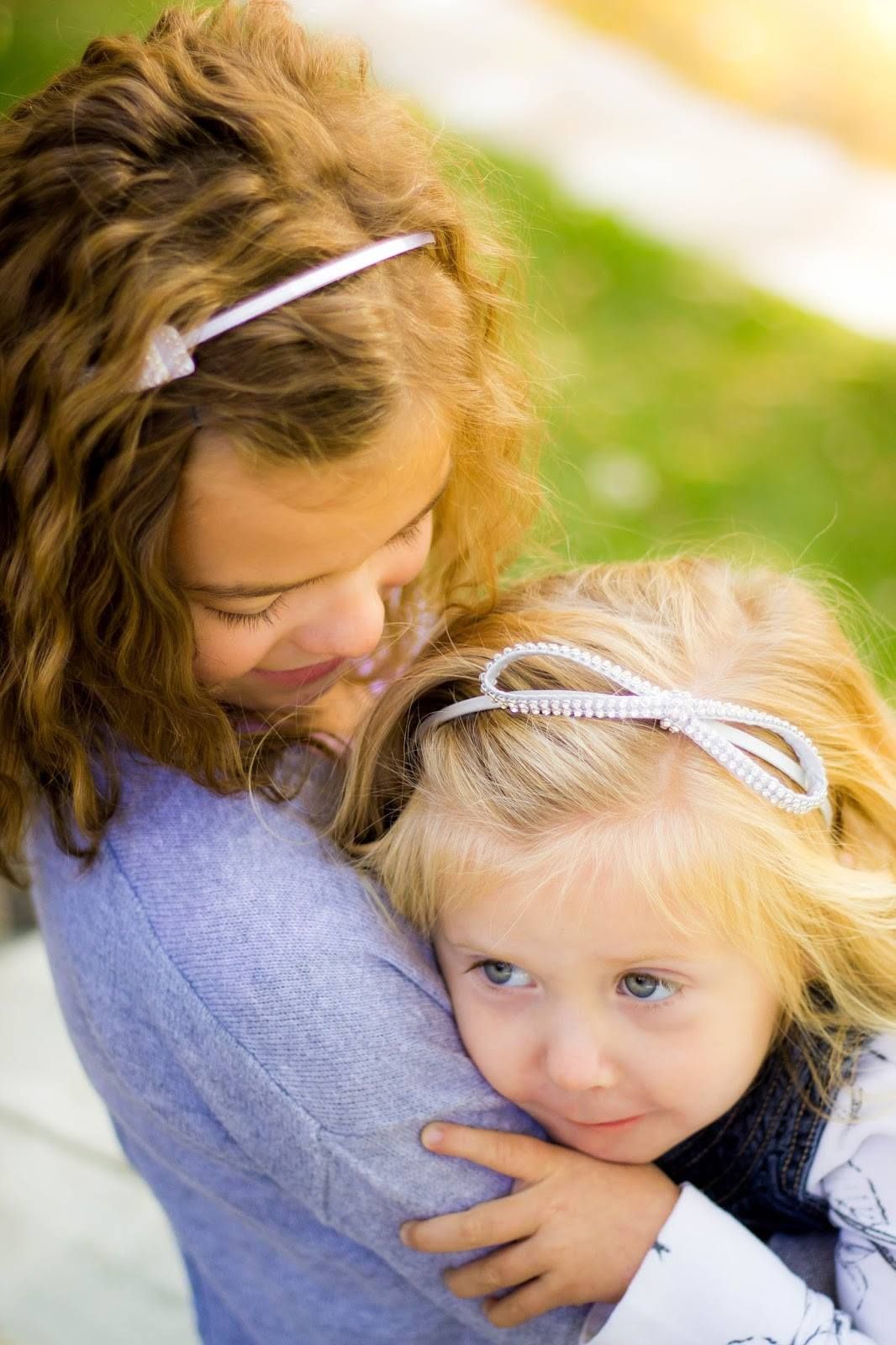 Two people sharing tender moment in soft lighting with white hair ribbons.