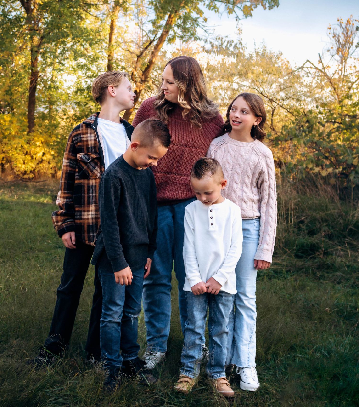 Group photo of family members standing together in a grassy field during sunset.