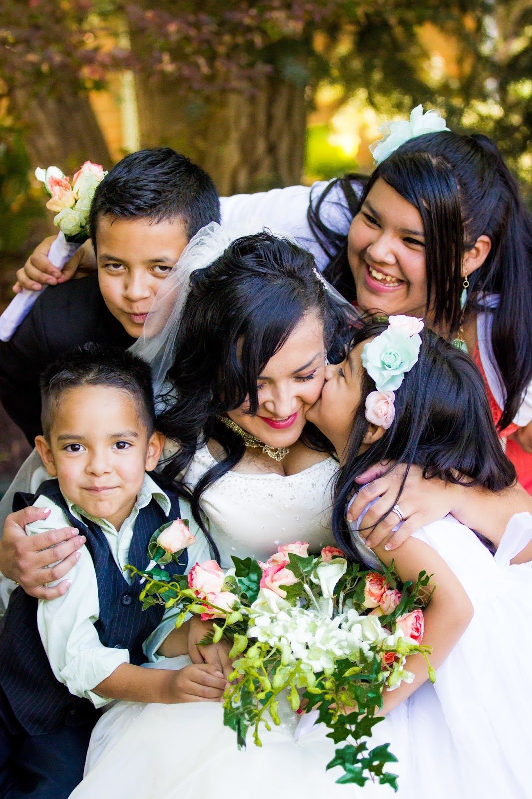 a bride surrounded by her children on her wedding day.