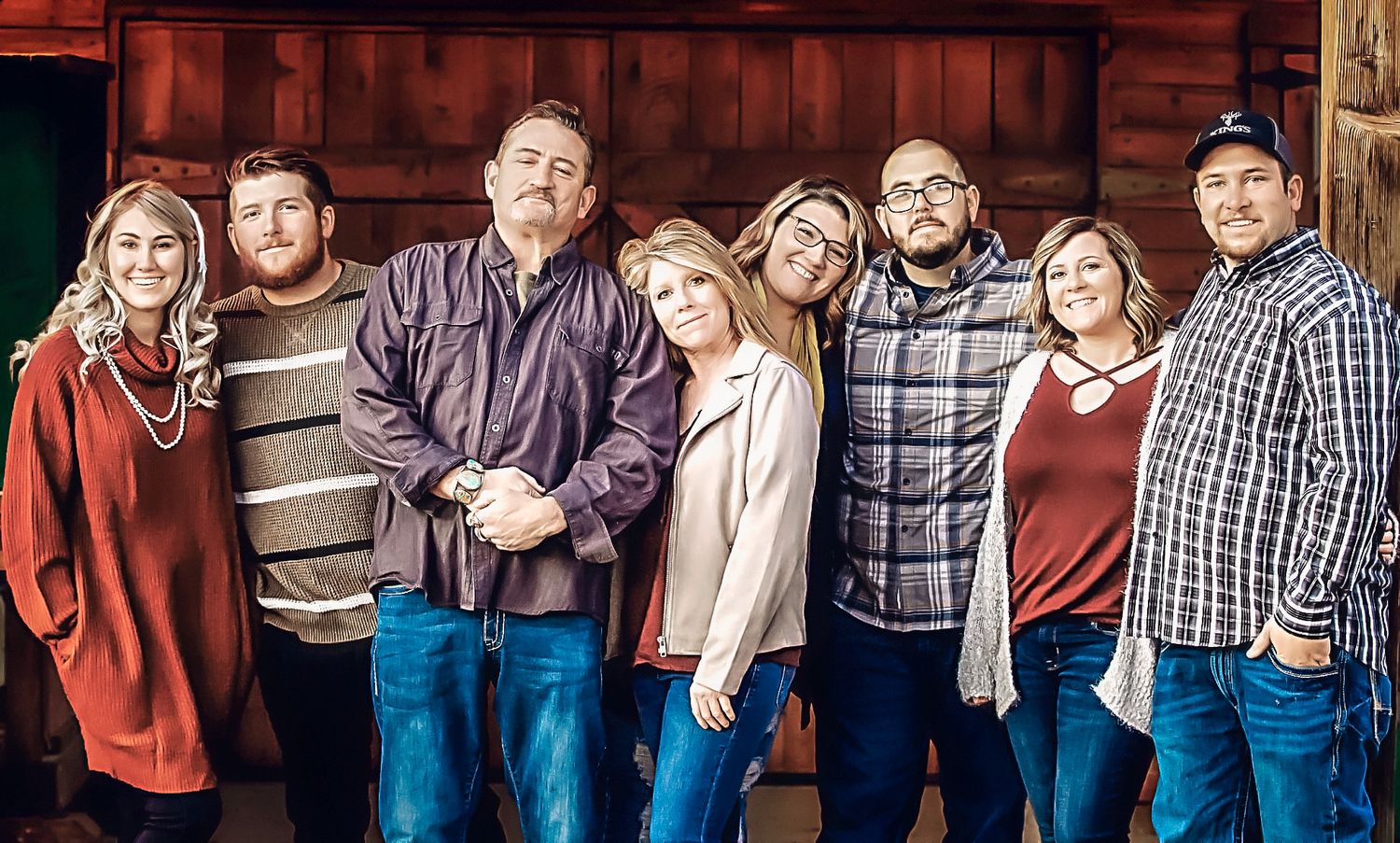 Group photo session against a rustic wooden wall background in casual attire.