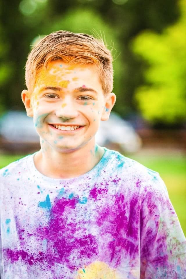 Progressive shots showing someone covered in purple and blue powder paint outdoors.