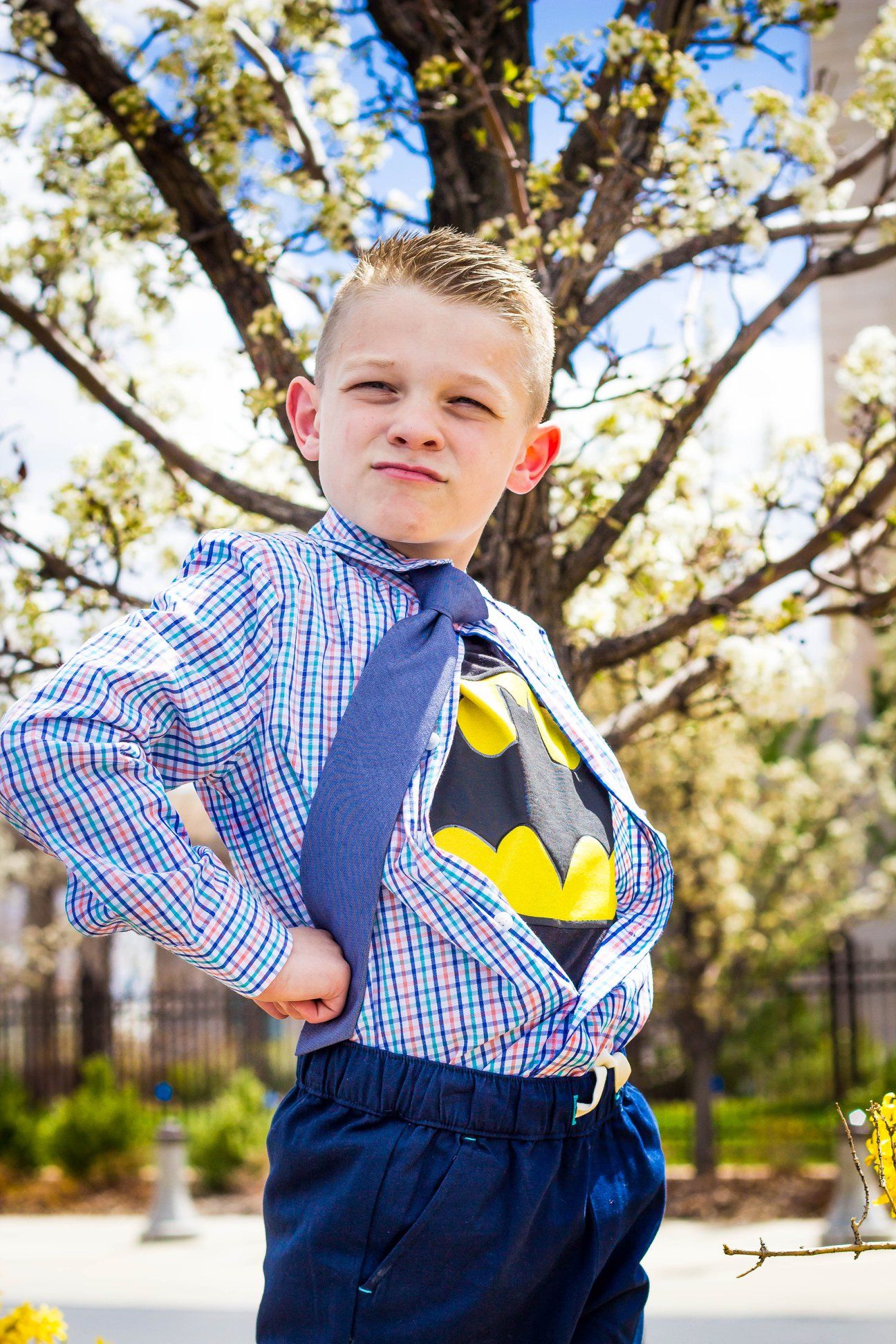 Series of playful poses showing child in plaid shirt and navy pants outdoors.