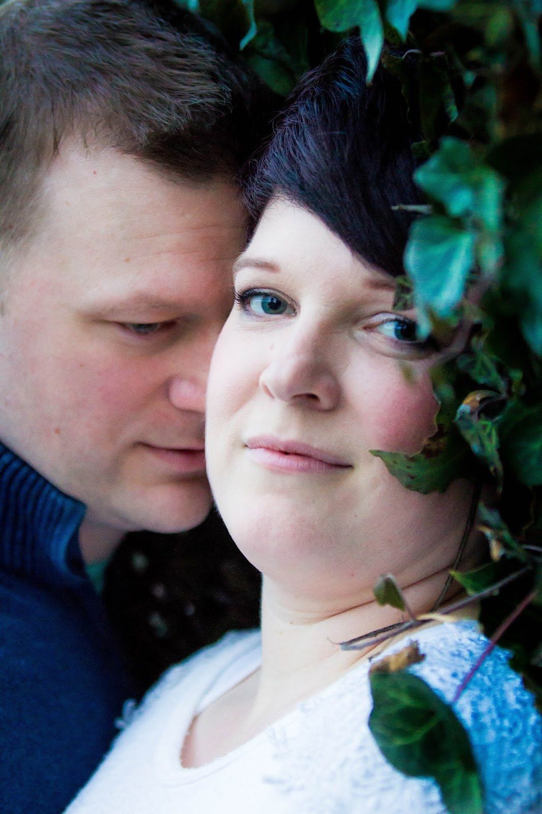 Intimate close-up portraits of couple among green foliage.