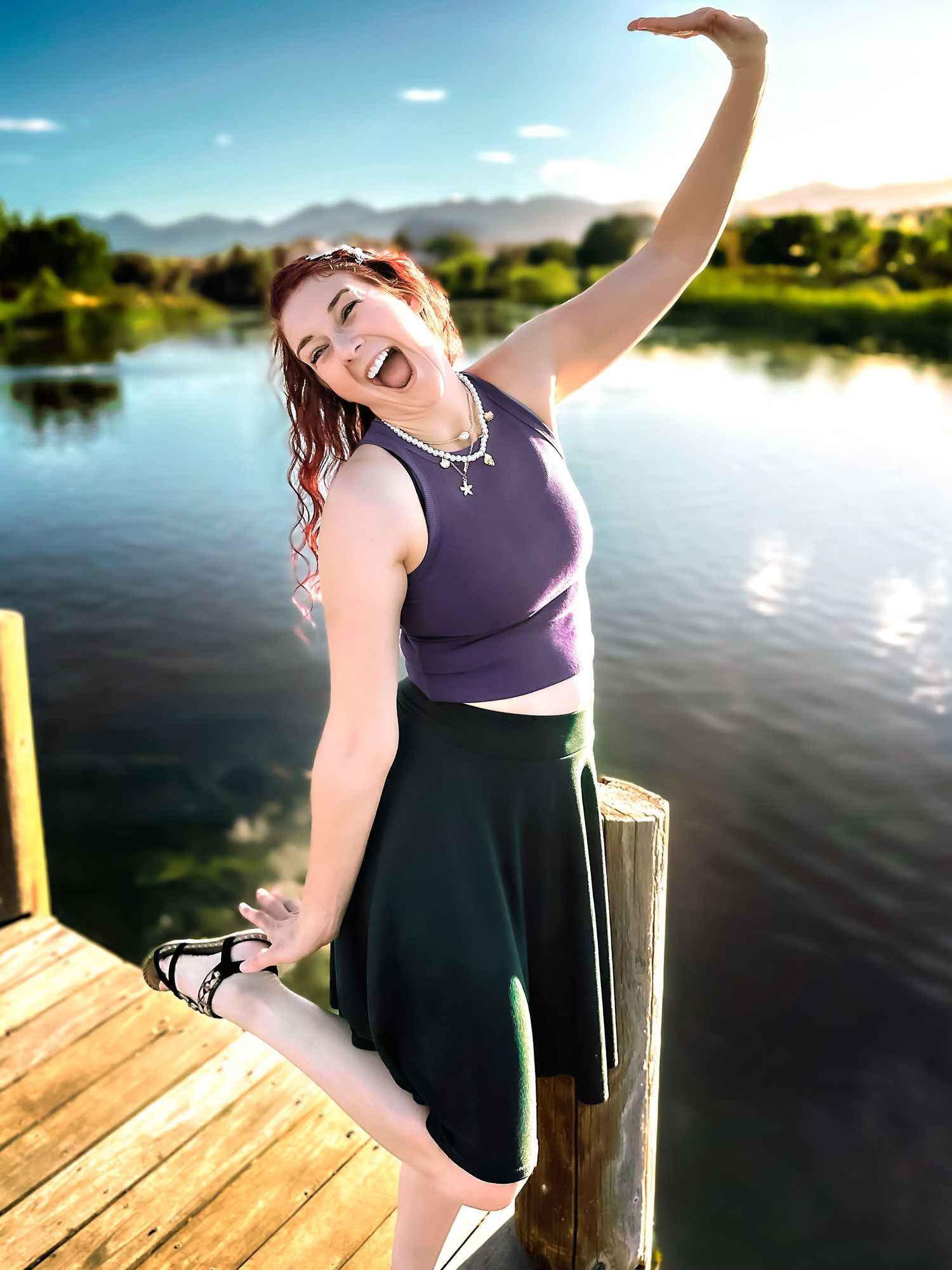 Dancing movements captured on a lakeside dock with mountains in the background.