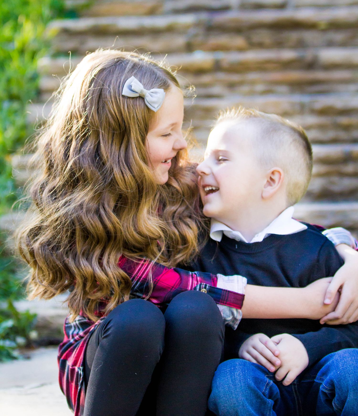Candid outdoor photo sequence showing playful interaction between two people against a stone wall background.