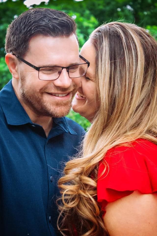 Couple in navy and red outfits share intimate moments during an outdoor portrait session.