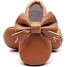 Brown leather baby moccasins and shoes arranged in a row on white background.
