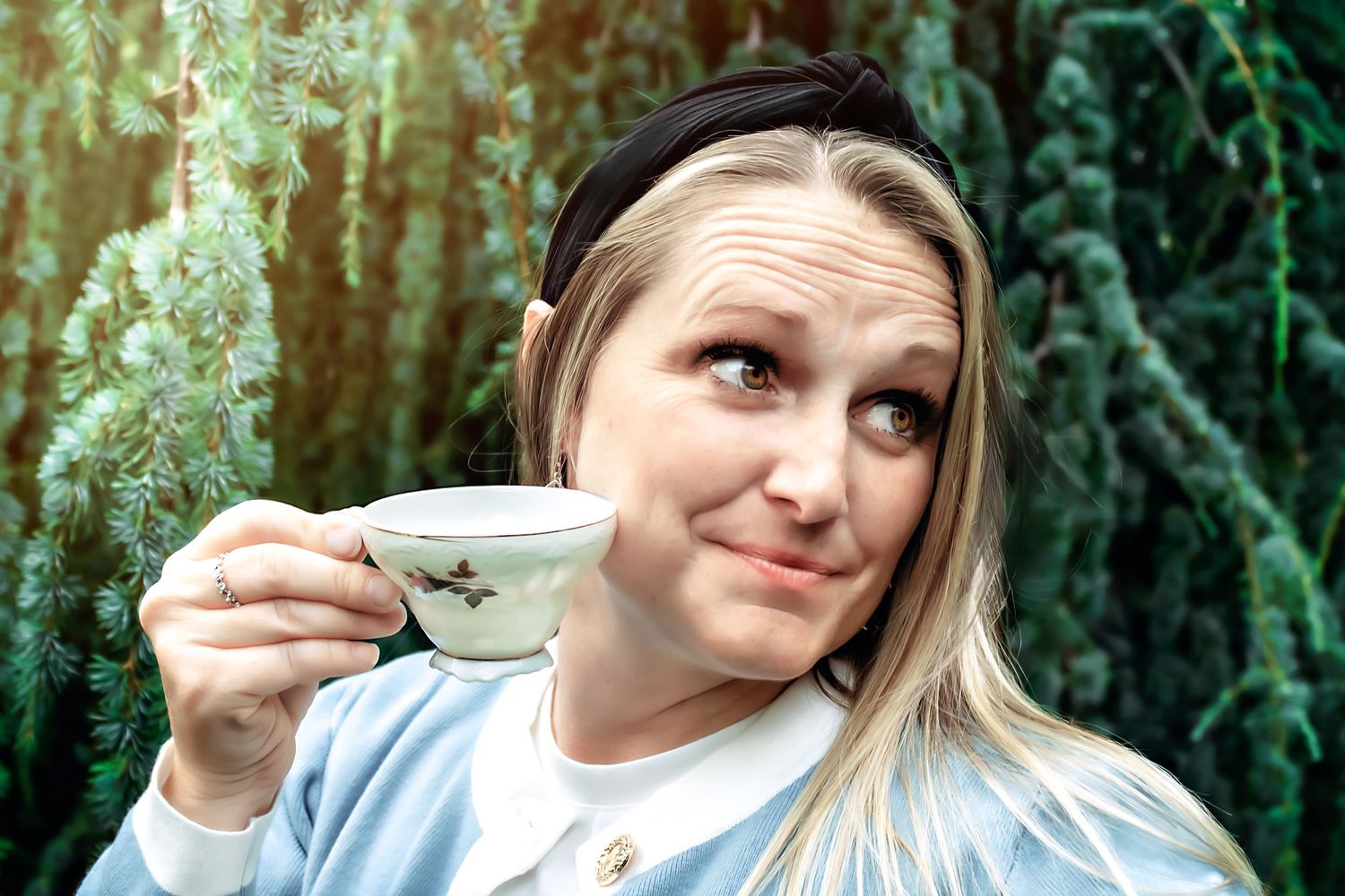 Whimsical tea party themed photoshoot with teacup in garden setting.