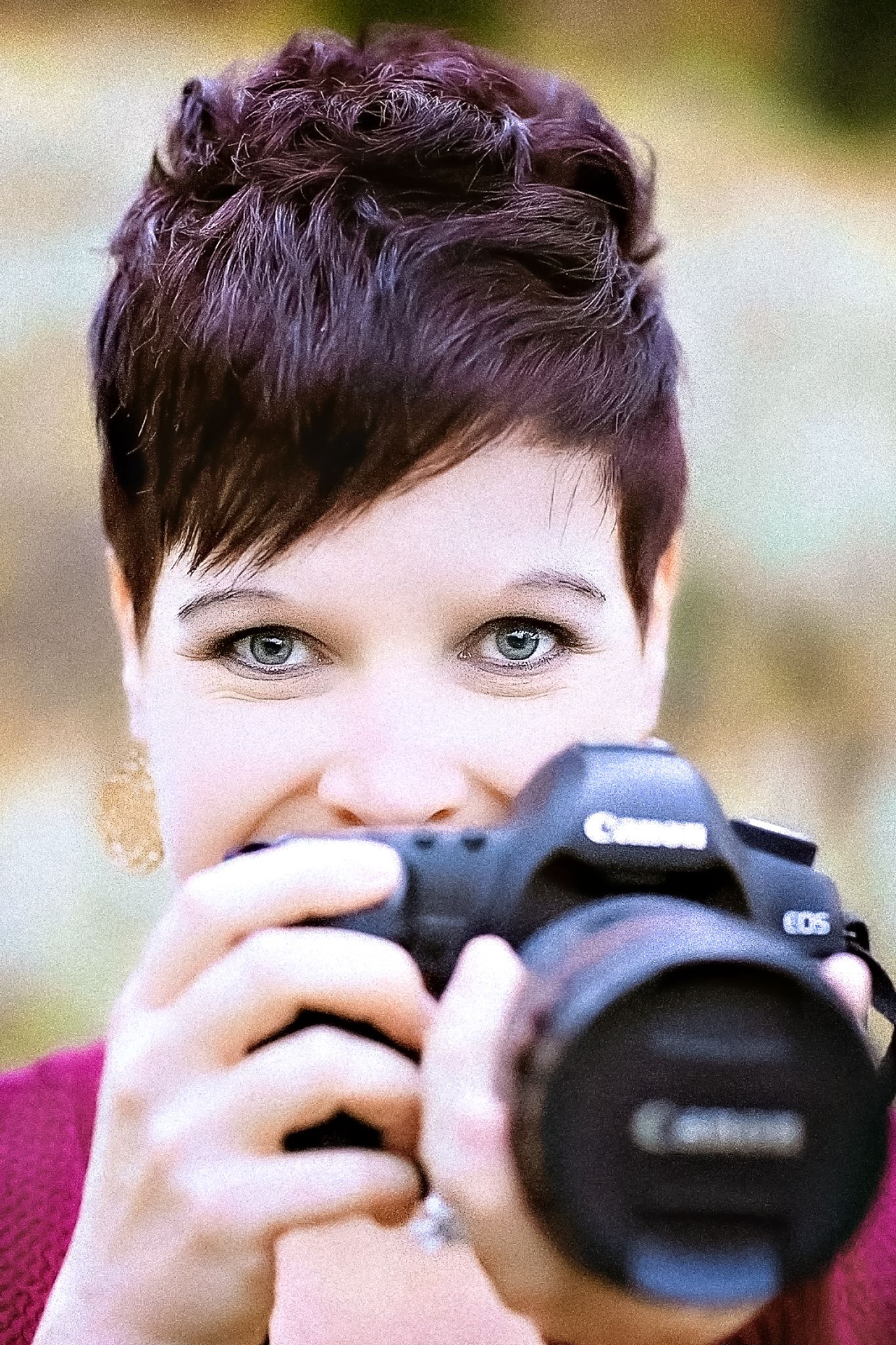 A photographer with short dark hair captures images with a Canon DSLR camera.