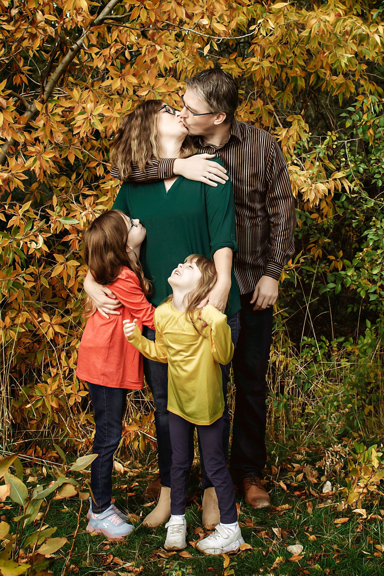 Family group photo against a backdrop of golden autumn foliage.