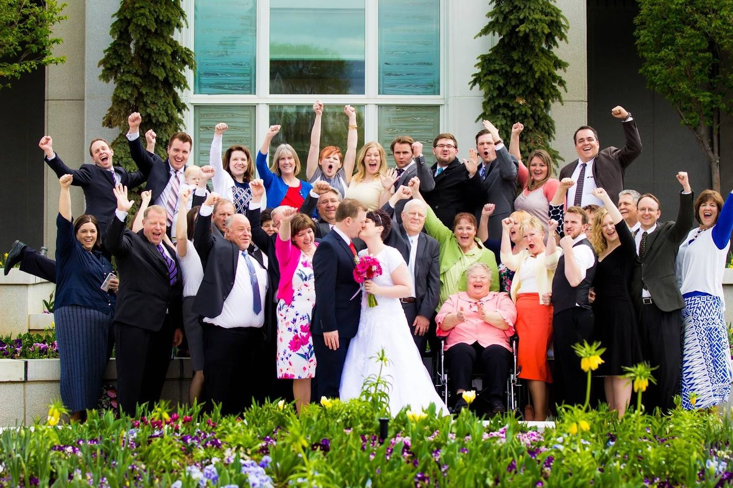 A bride and groom surrounded by family on both sides on their special day.