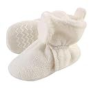 White baby shoes and booties lined up in a horizontal display.