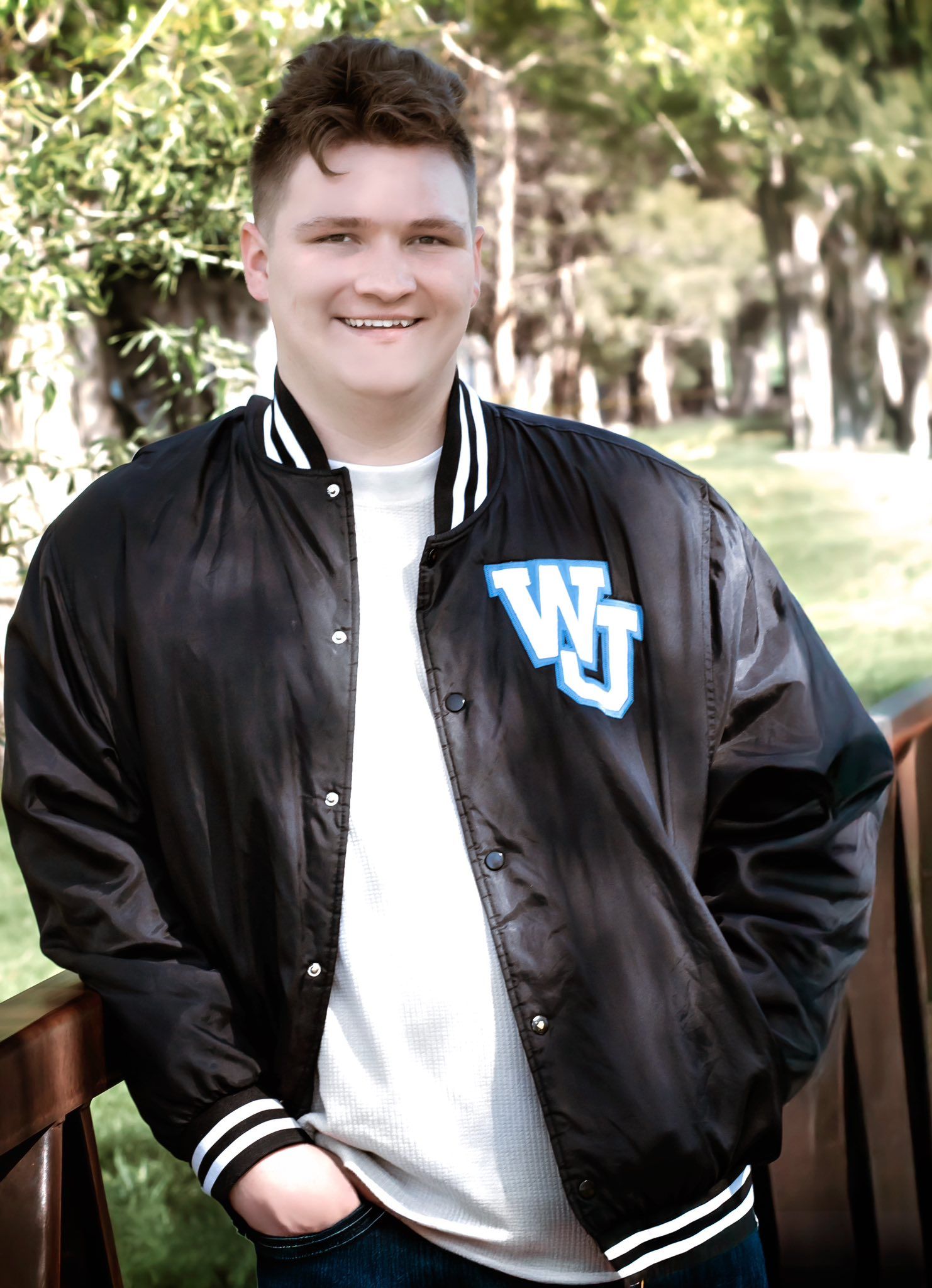 Athletic style portraits featuring a varsity jacket and casual white t-shirt outdoors.
