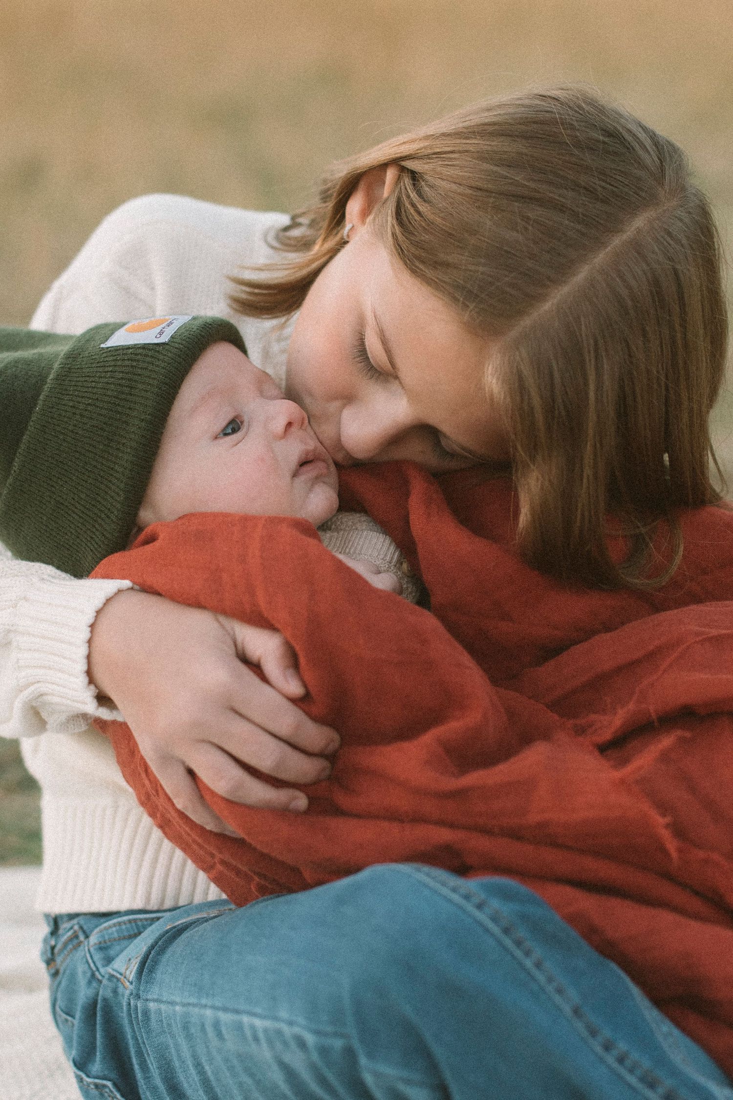 Tender moments captured between two people in cozy sweaters lying down together.