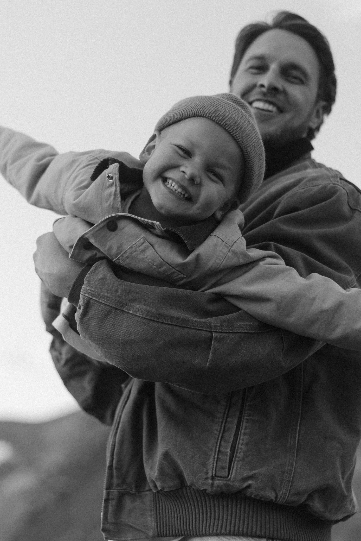Playful black and white sequence showing joyful laughter and embraces outdoors.