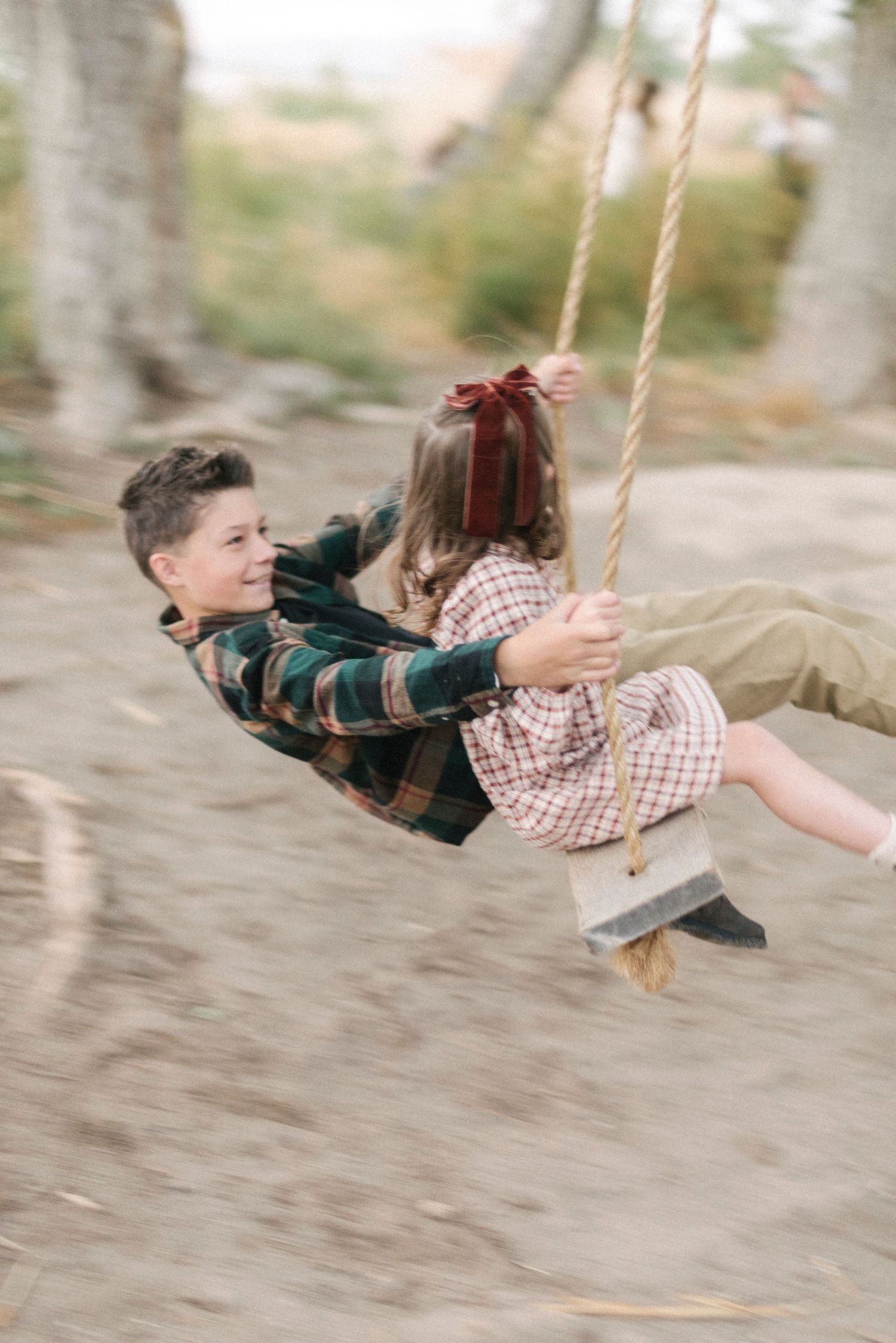 Action shots of children swinging joyfully on a rope swing outdoors.
