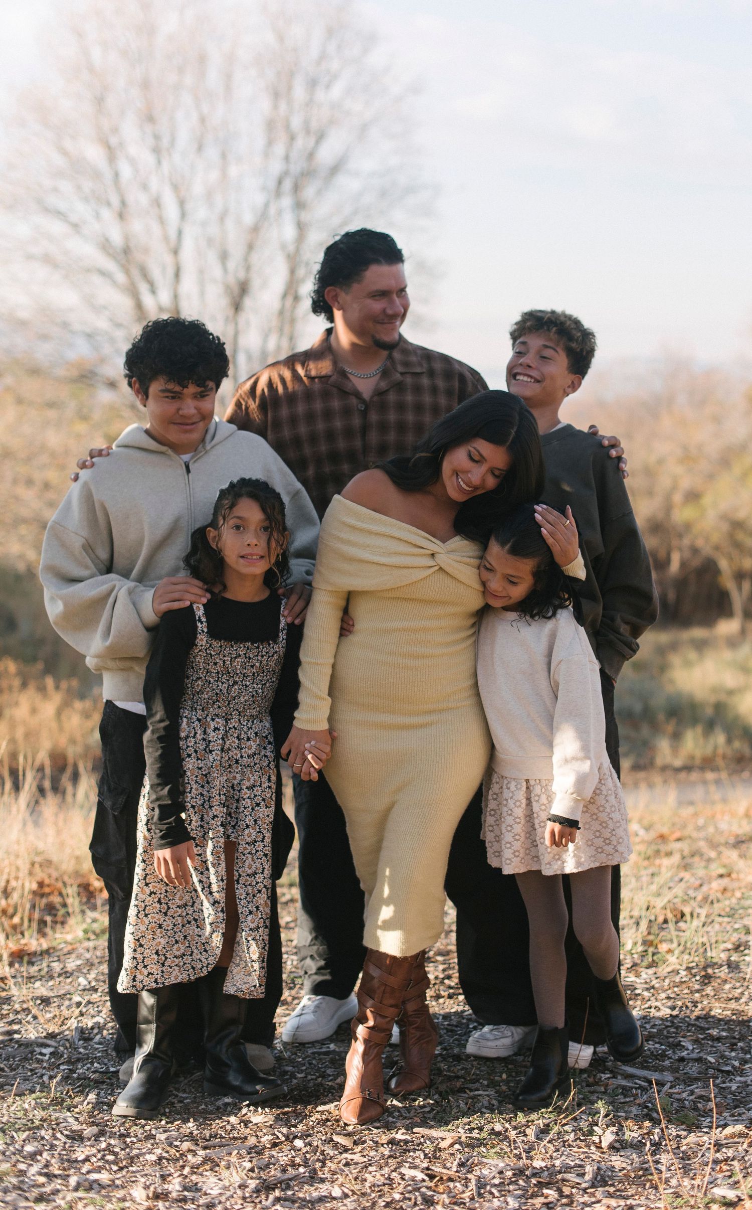 A family group poses together outdoors during a professional photo session.