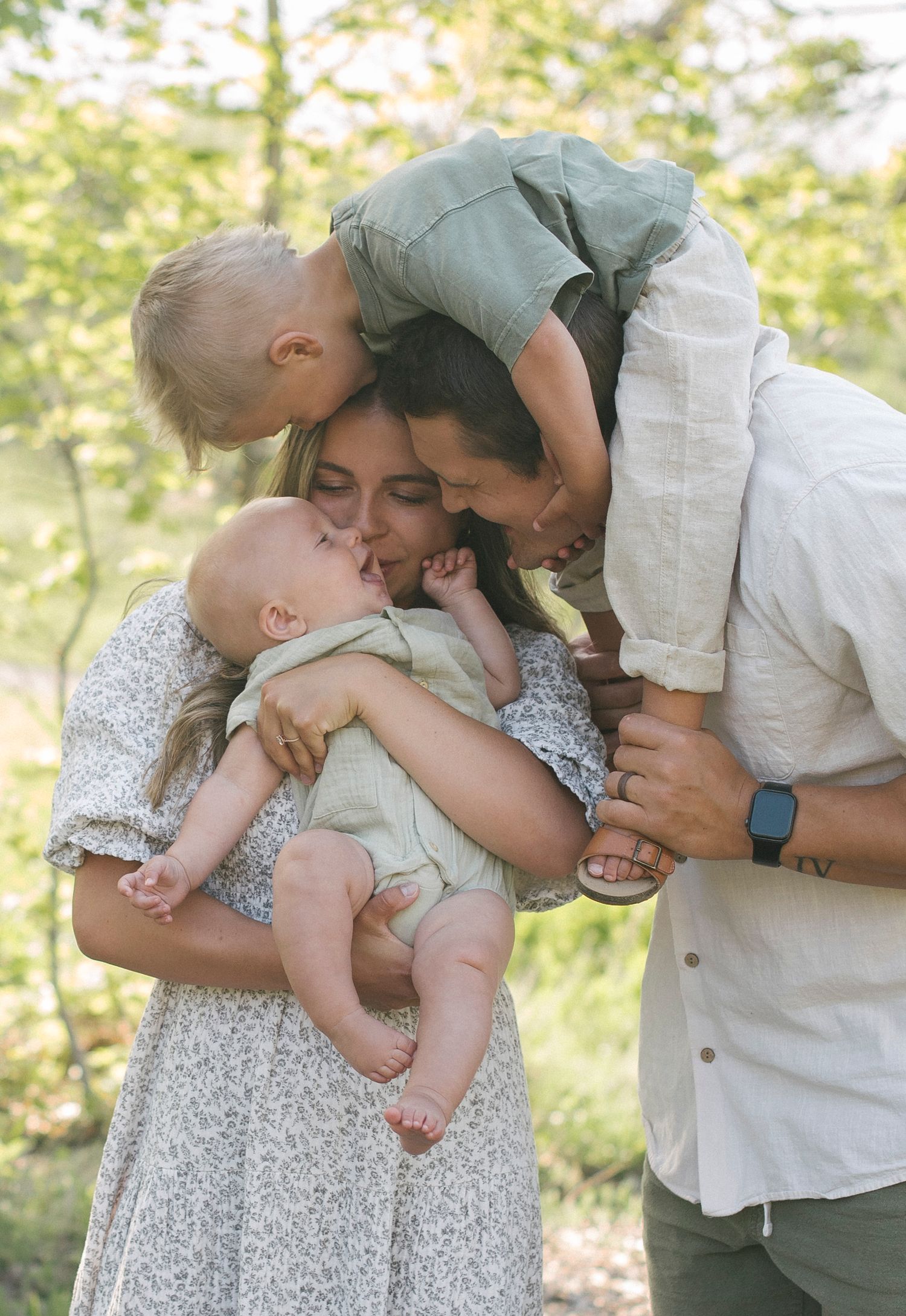 Tender family moments captured in a sunny outdoor setting with natural expressions.