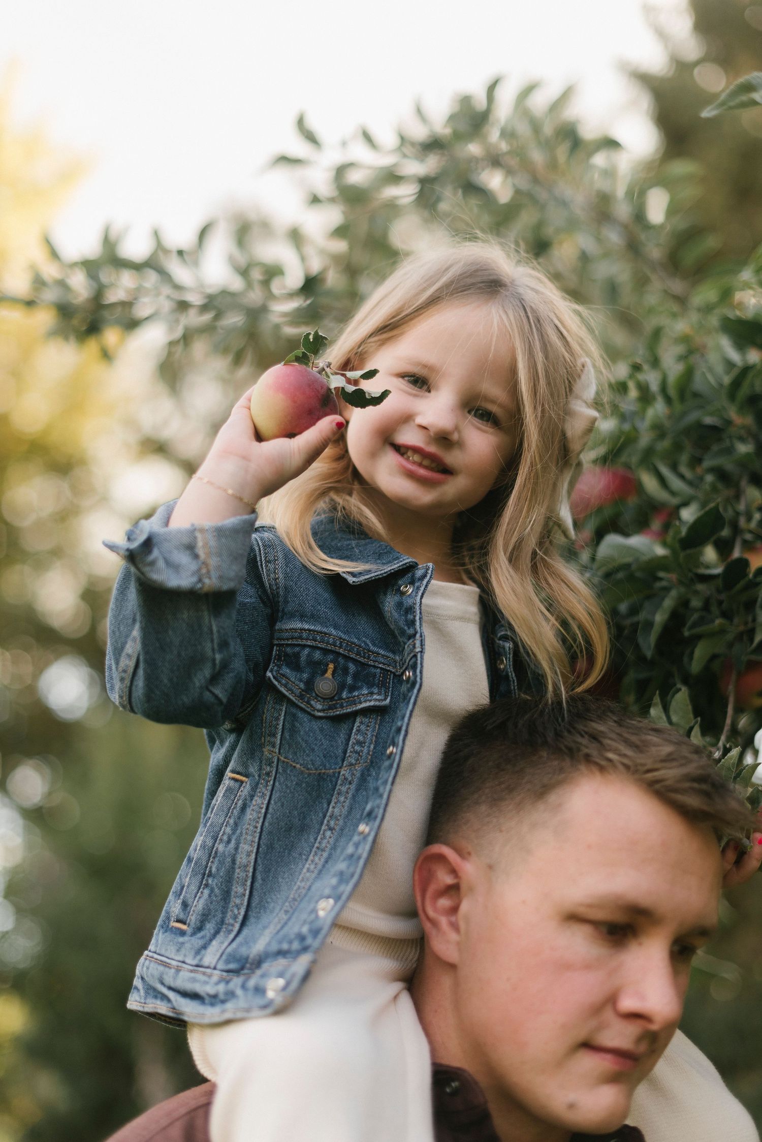 Playful moments captured near apple trees during outdoor photo session.