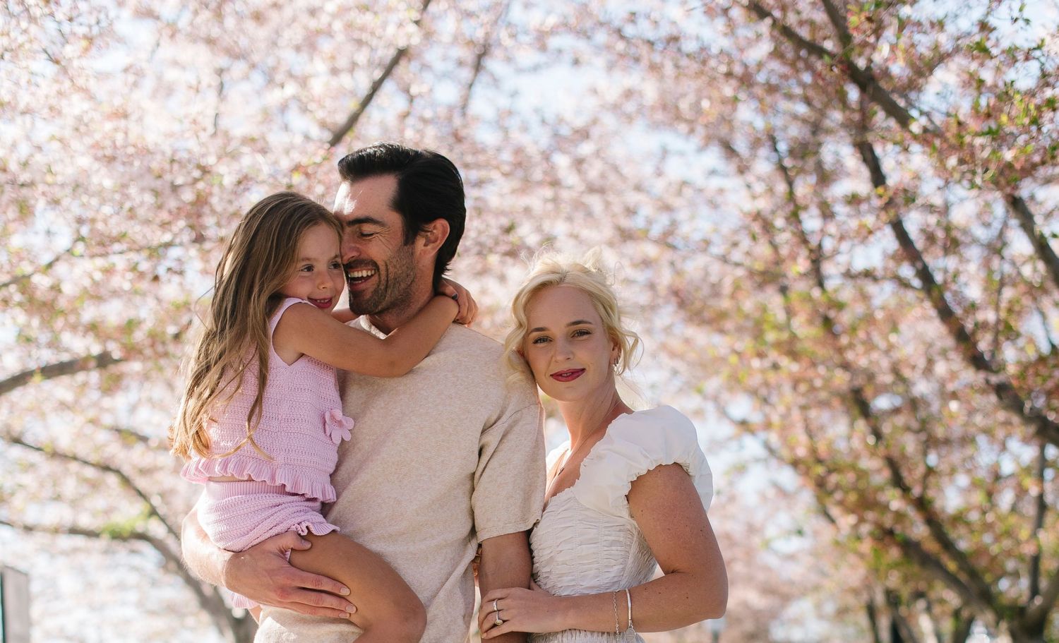 A series of intimate family moments captured under blooming cherry blossom trees.