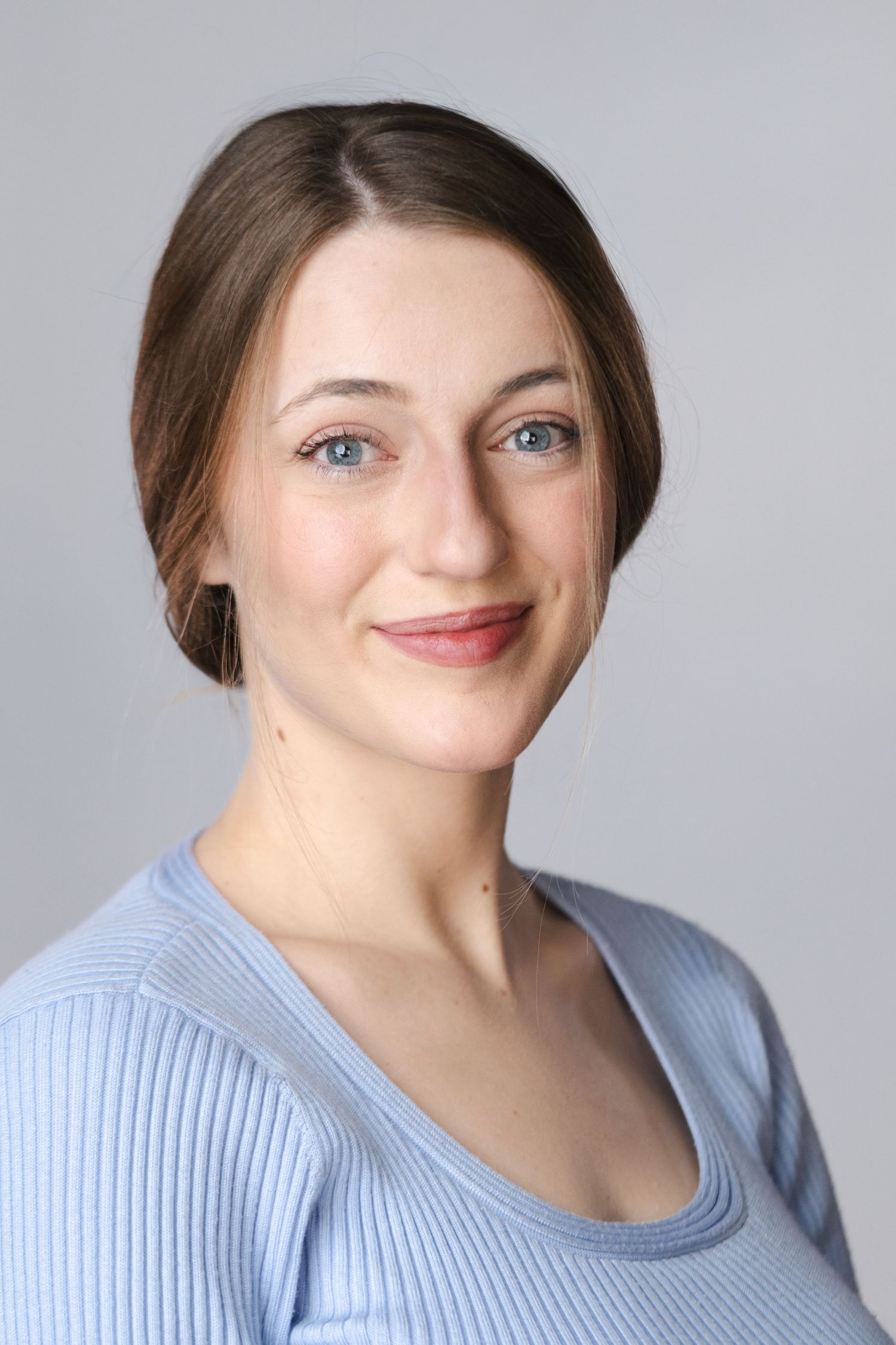Series of portrait shots showing different expressions in a light blue sweater against gray background.