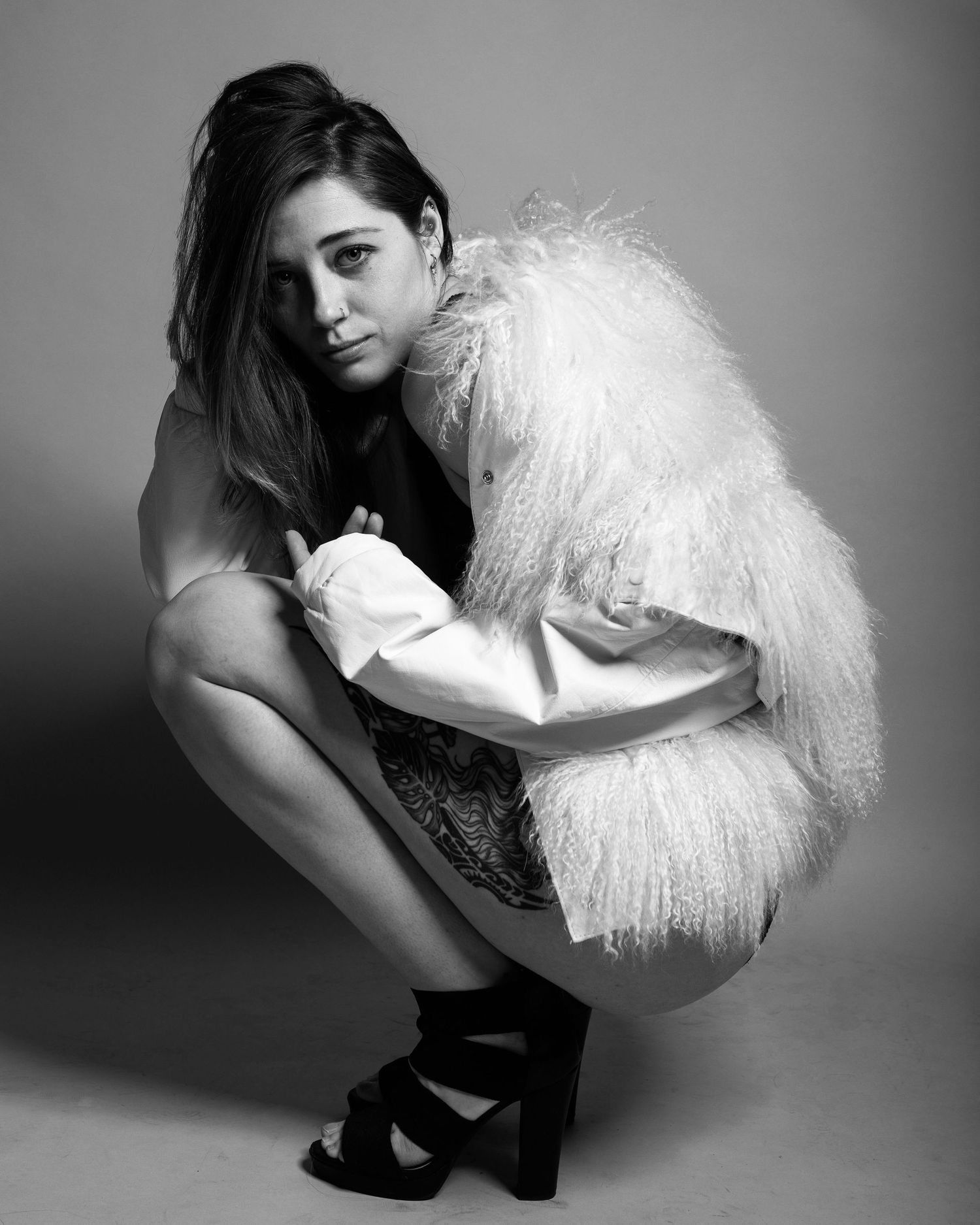 Artistic black and white portraits with white feather prop and dramatic poses.