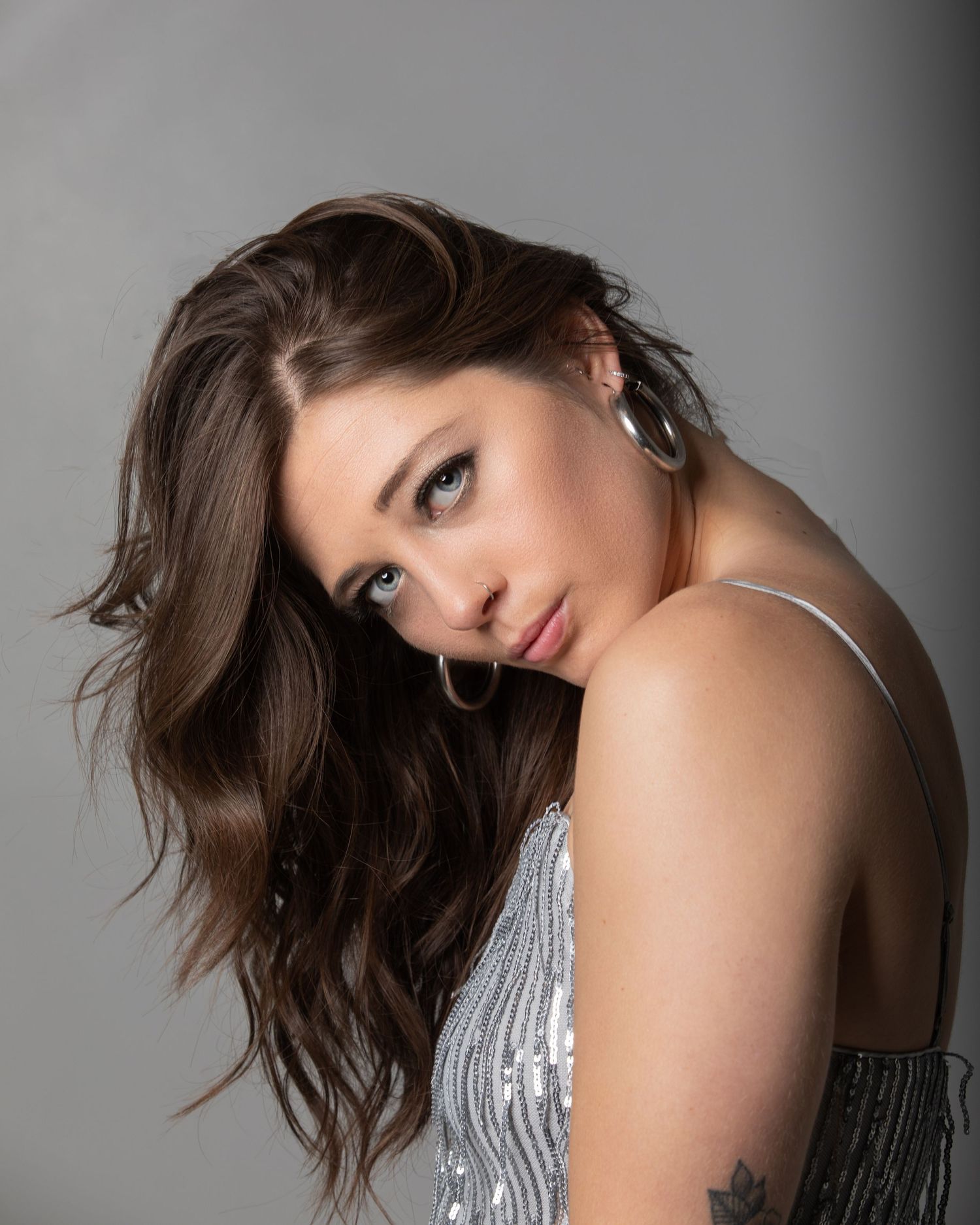 Studio portrait with dramatic lighting and silver sequined details.
