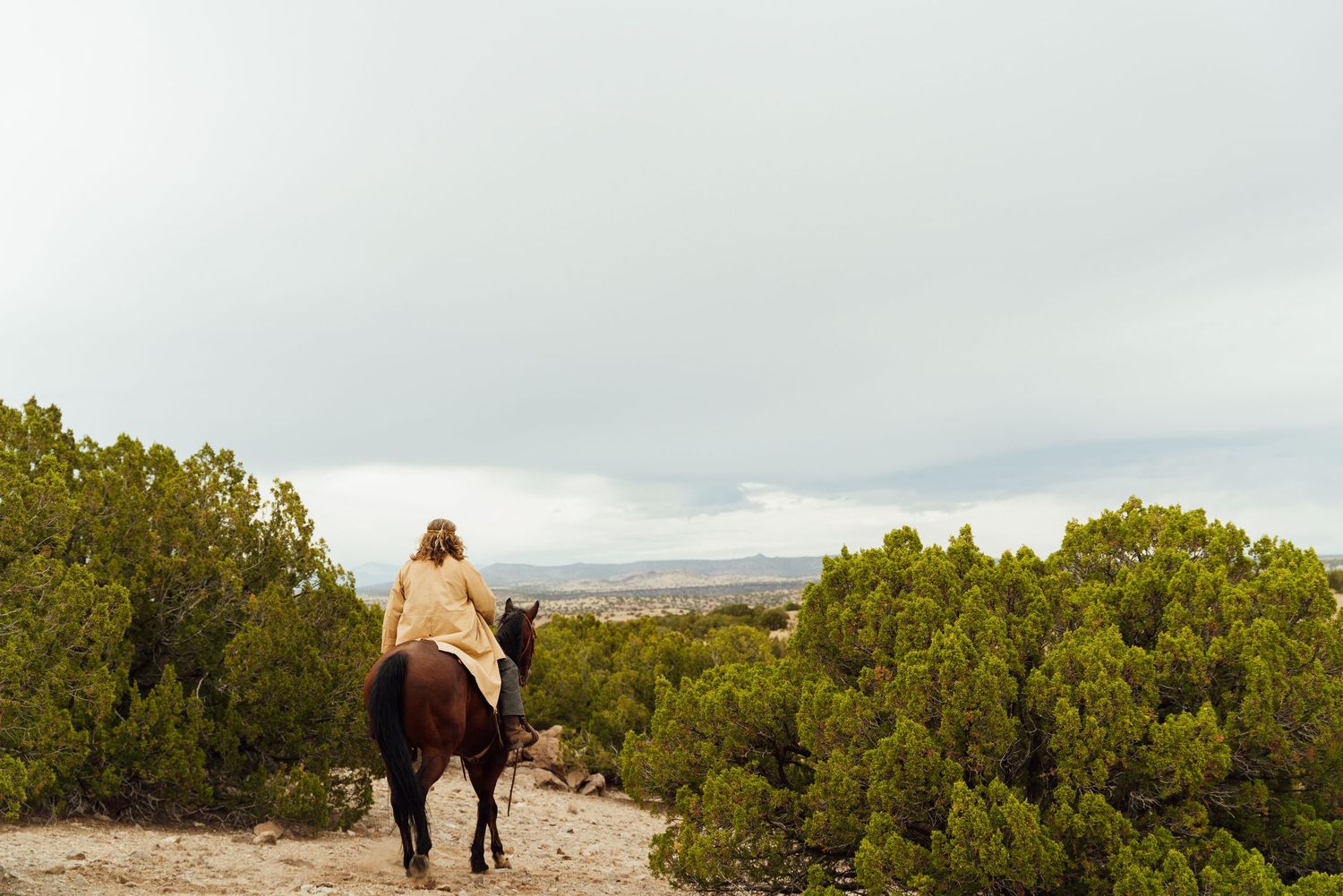 Wide landscape shot of film production team working in desert terrain.