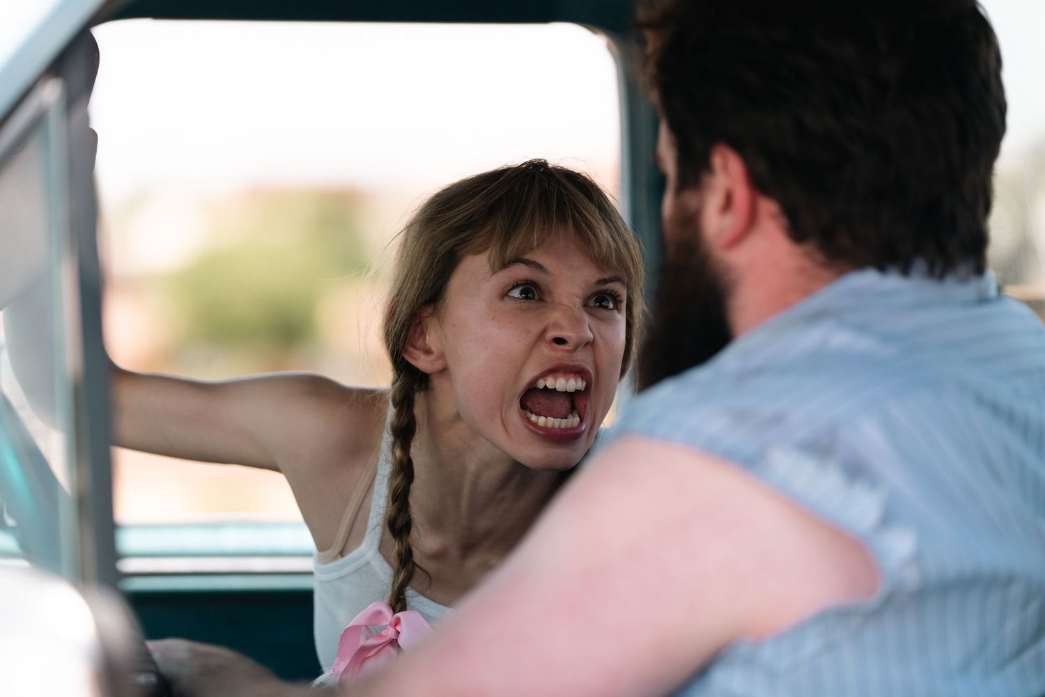 Dramatic scene being filmed inside vintage car during movie production.