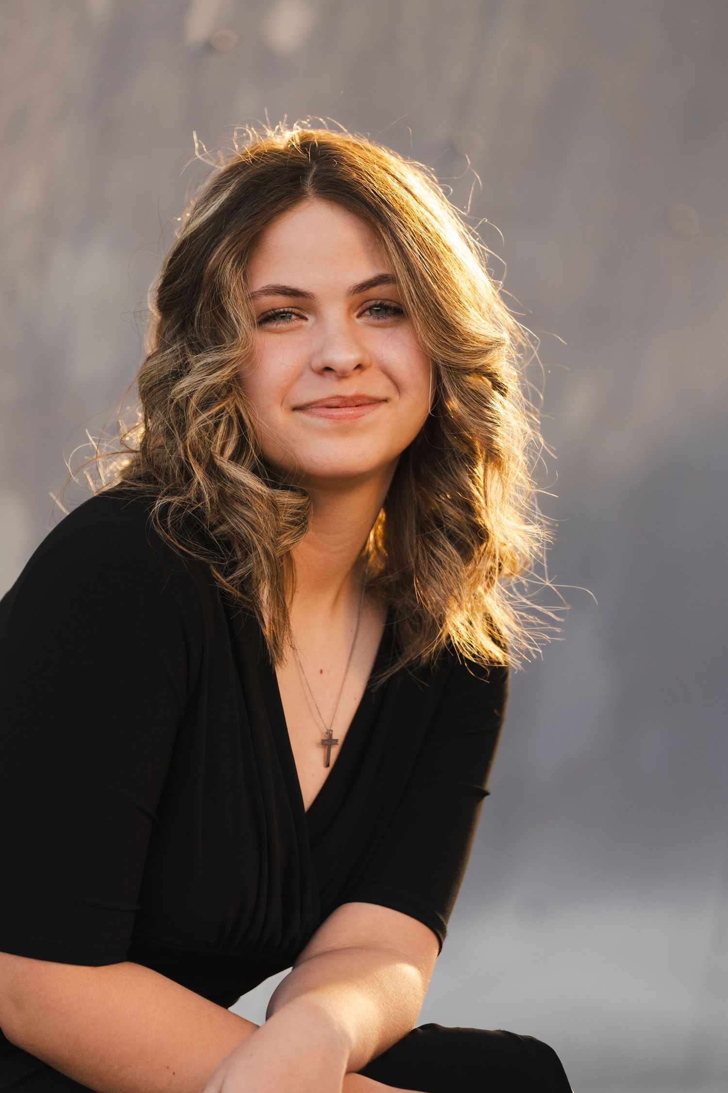 New Mexico Photographer - Graduation New Mexico Photographer - Graduation Portrait of woman in black top with sunlit hair smiling warmly.