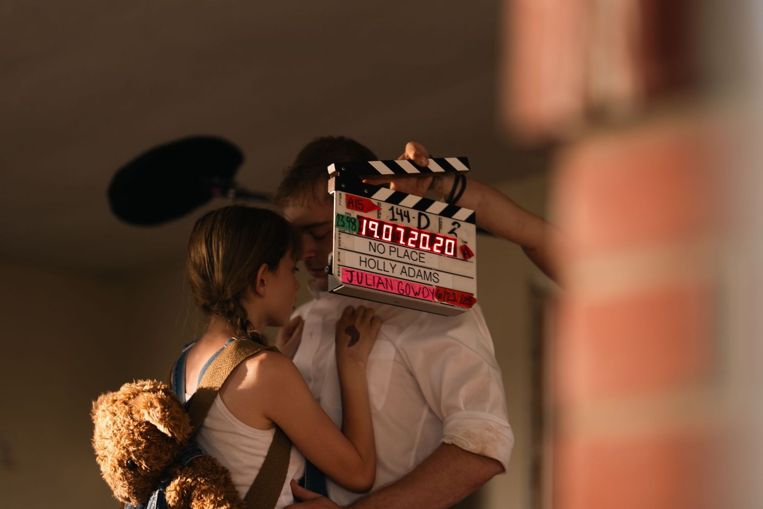 Film production crew using clapperboard and cameras during sunset shoot.