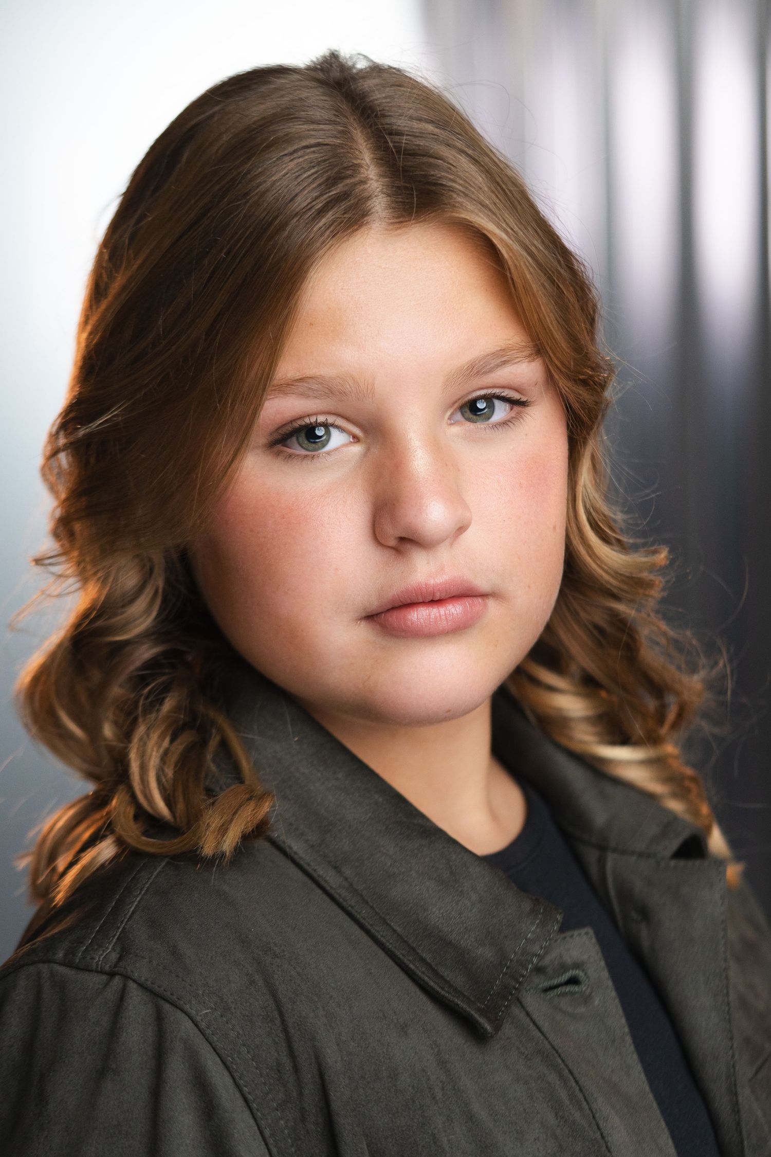 Portrait series showing different angles of a young person with wavy brown hair wearing a dark jacket.