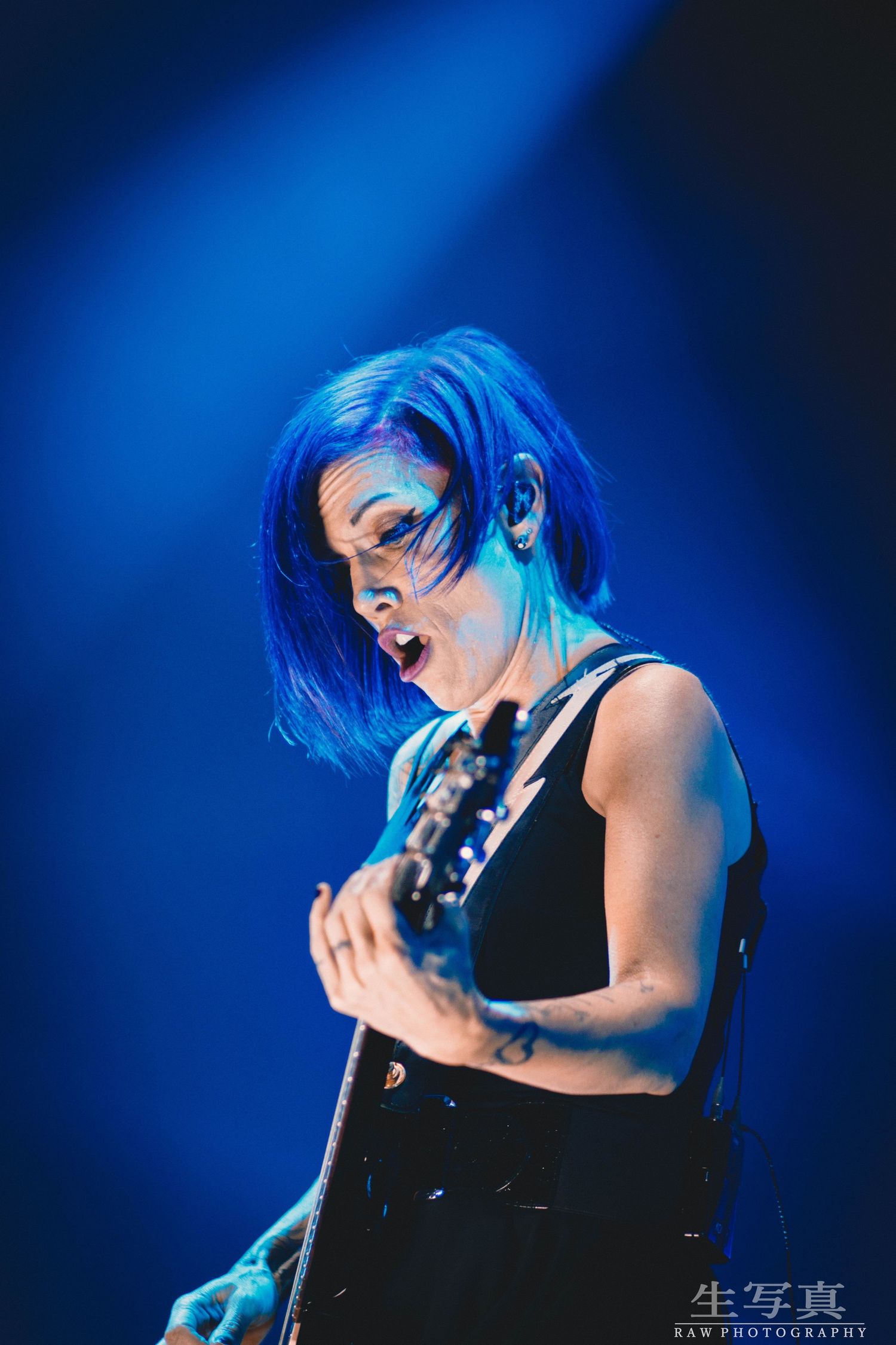 Performance shots with dramatic blue lighting showing musician in black attire.