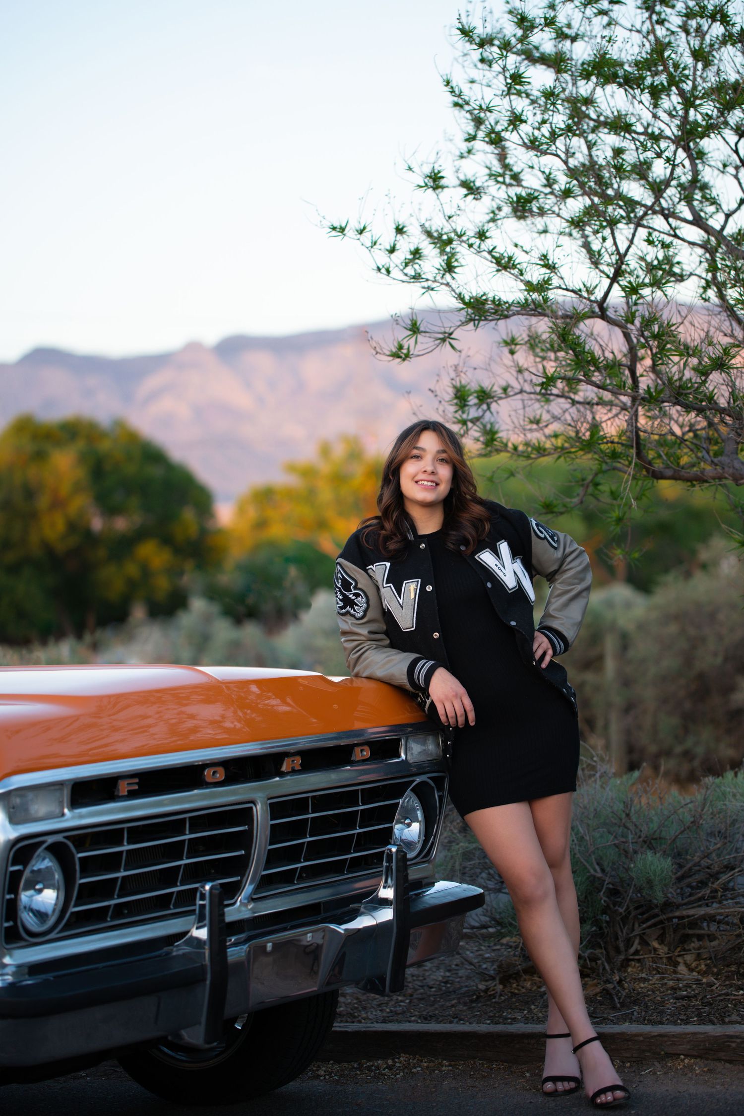 Stylish portrait session featuring a vintage car and desert mountain backdrop.