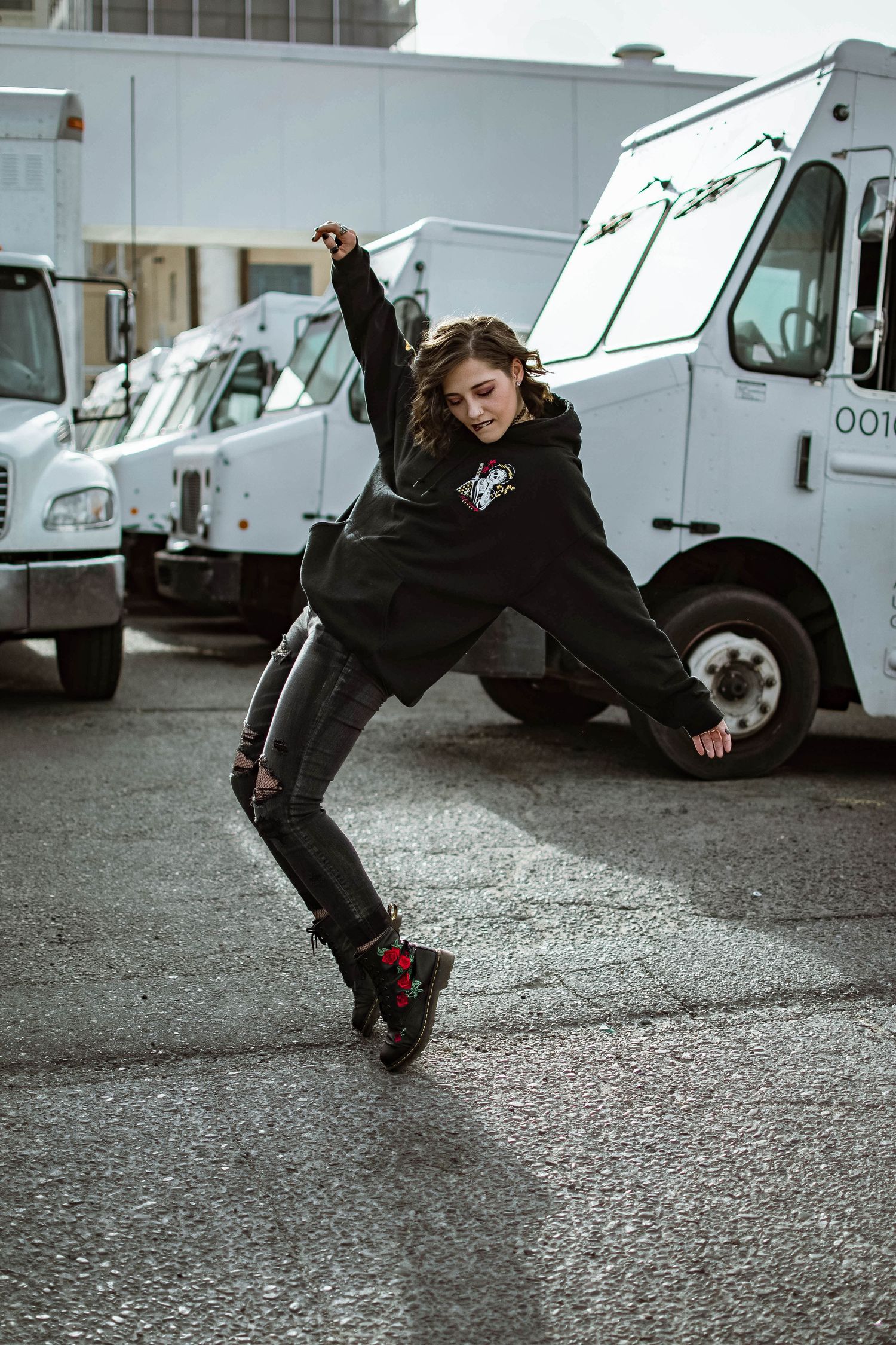 Dynamic action shot of person leaping between delivery trucks in parking lot.