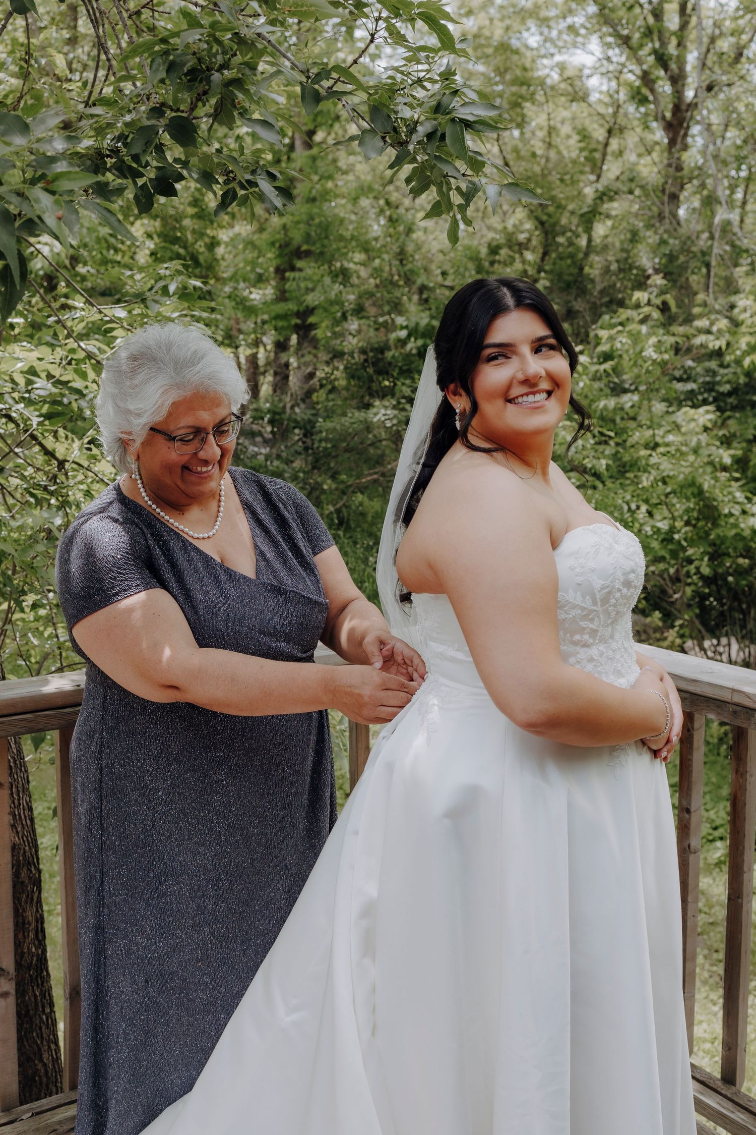 A tender moment shared between two people in wedding attire on a wooden deck.