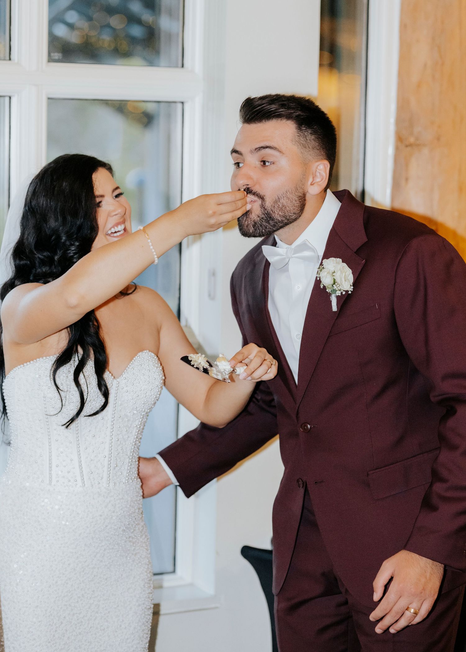 A couple in wedding attire playfully interact during their first look moment.