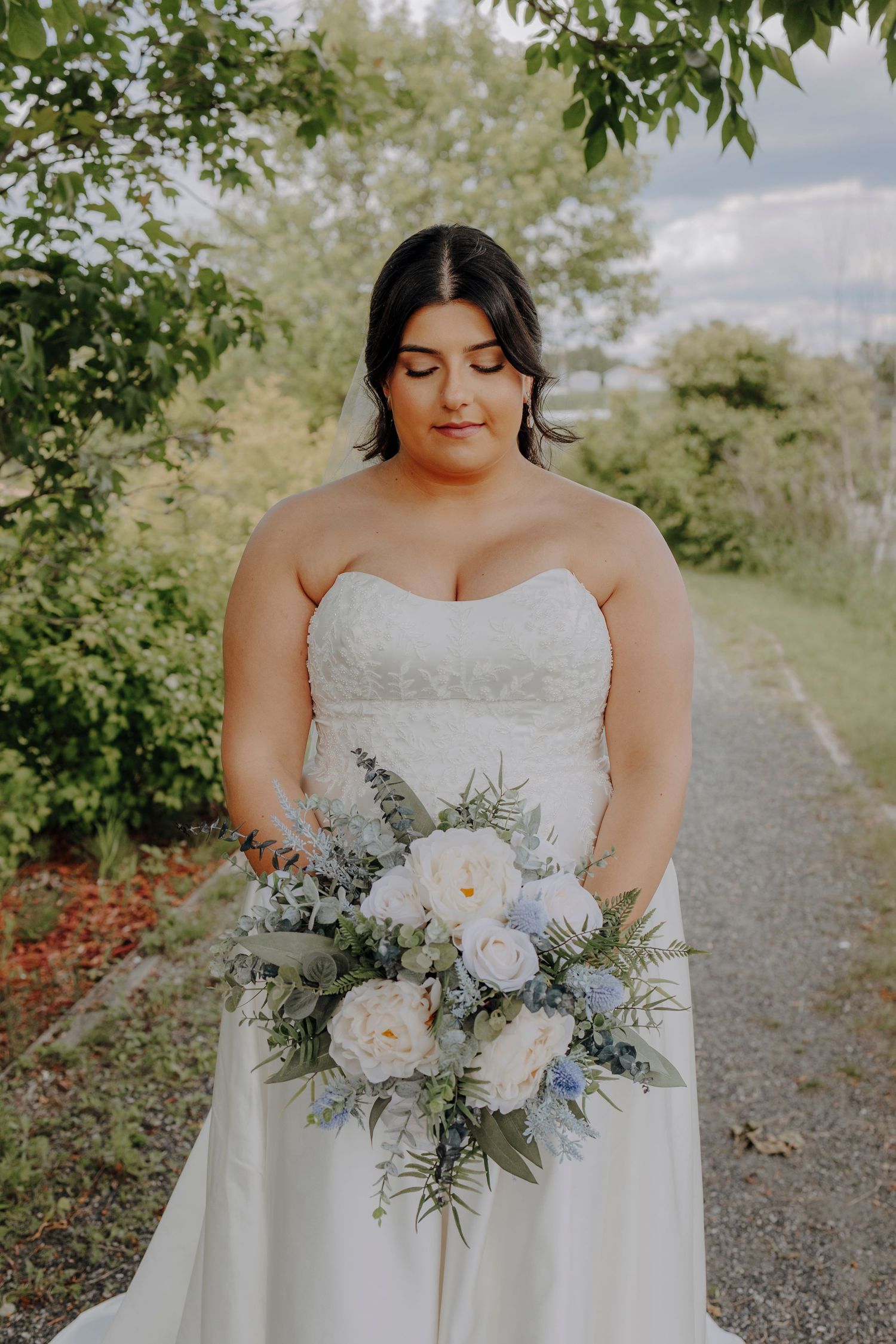 Elegant bridal bouquet featuring soft peach and white flowers with delicate greenery.