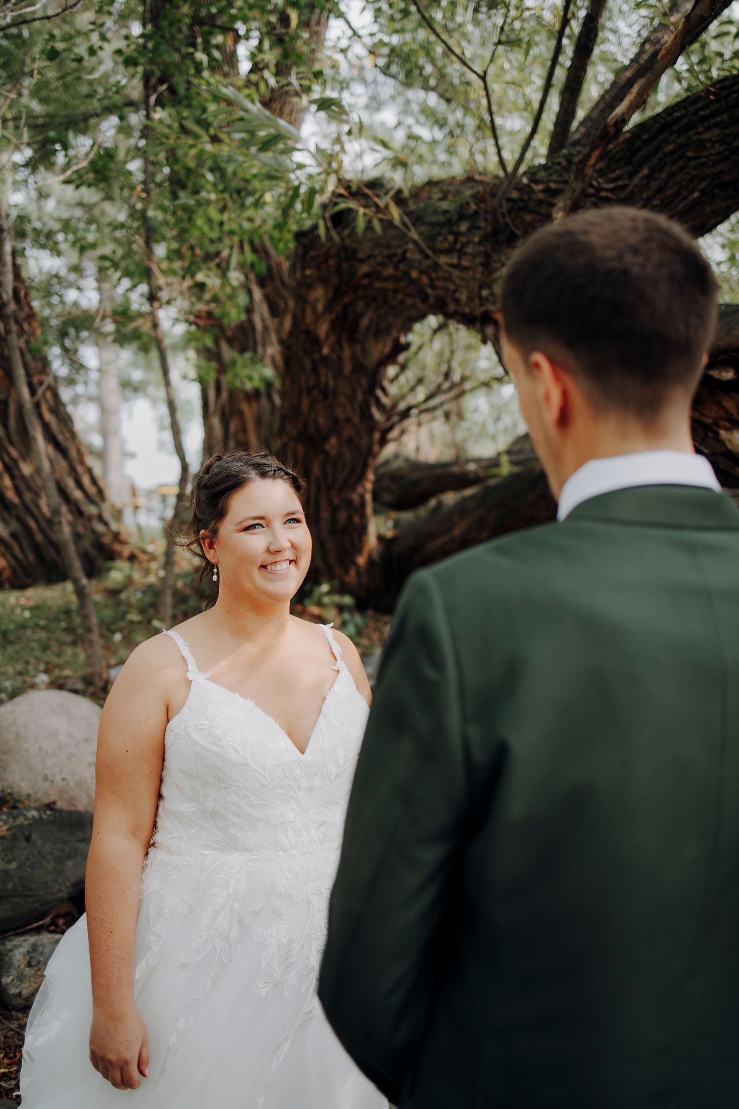 Intimate wedding portrait under trees with natural lighting.