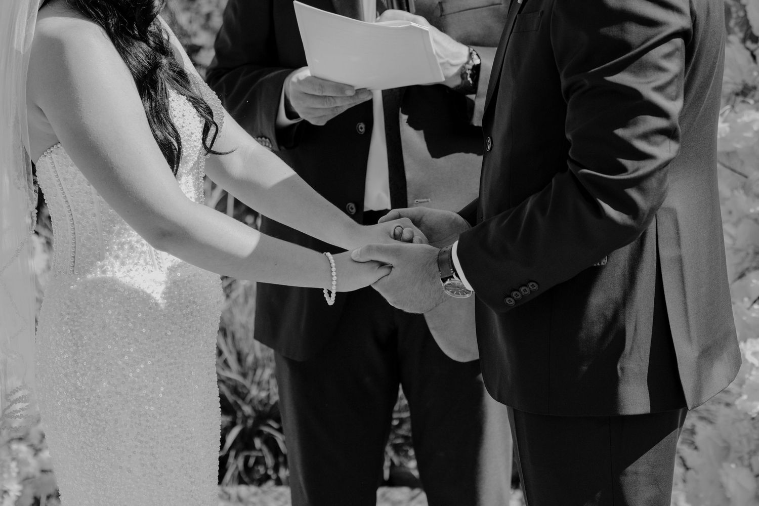 Wedding ceremony moments captured in black and white during vow exchange.