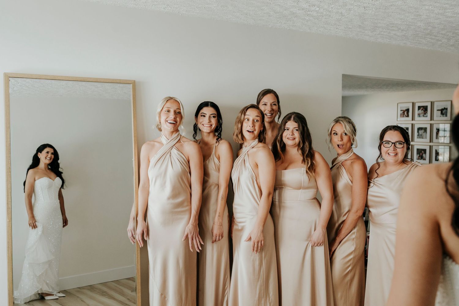 Row of bridesmaids wearing neutral-colored dresses standing together at a wedding.