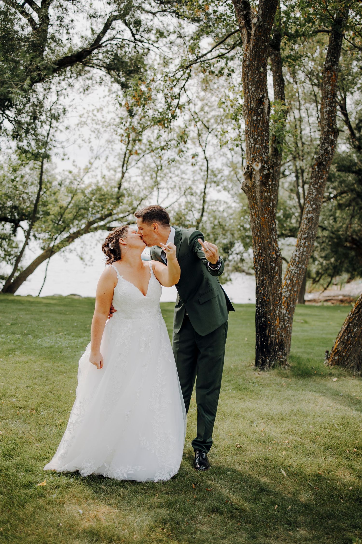 Sequence of wedding couple walking and embracing under trees in a grassy outdoor setting.