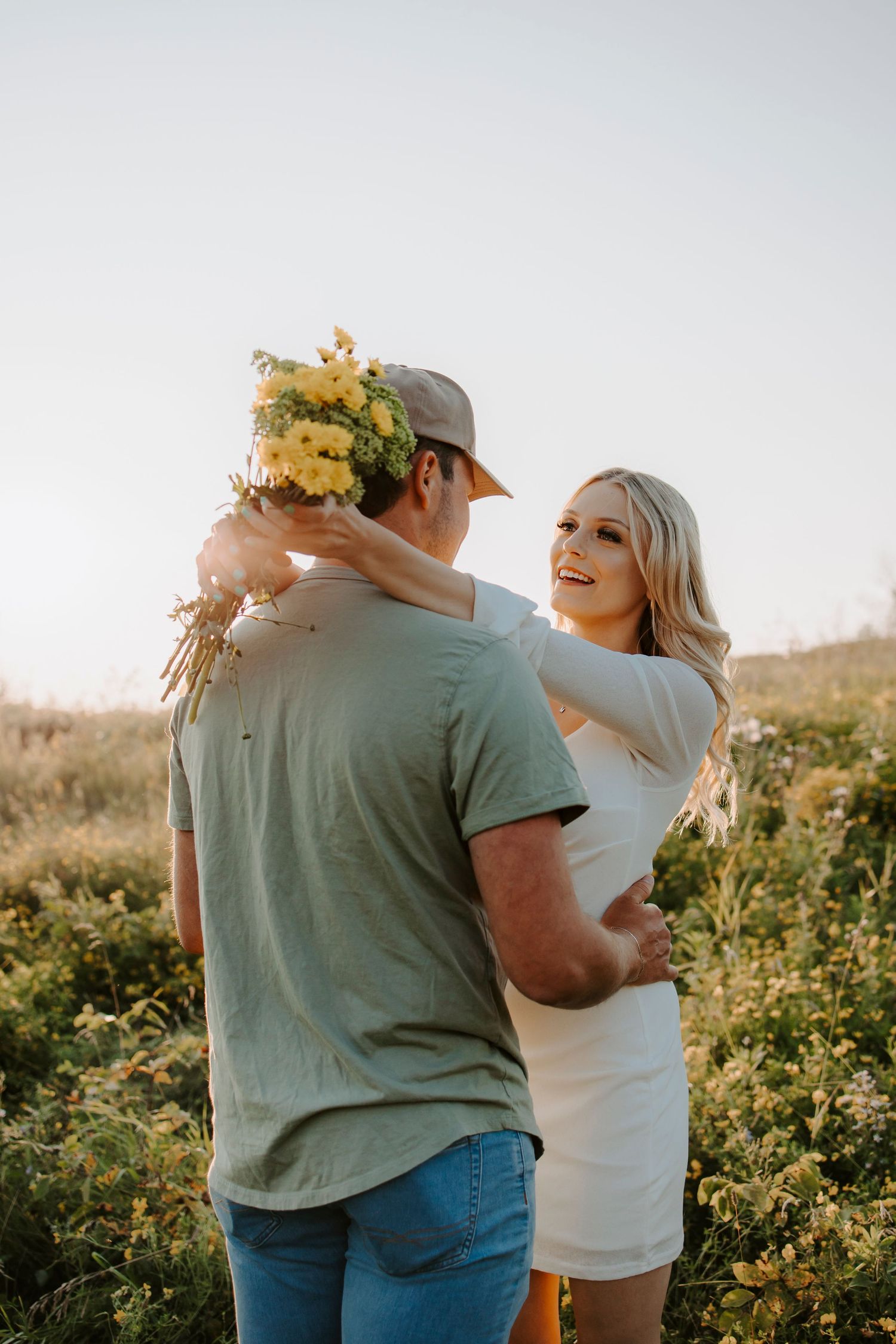 A romantic sunset photoshoot in a wildflower field with warm golden light.