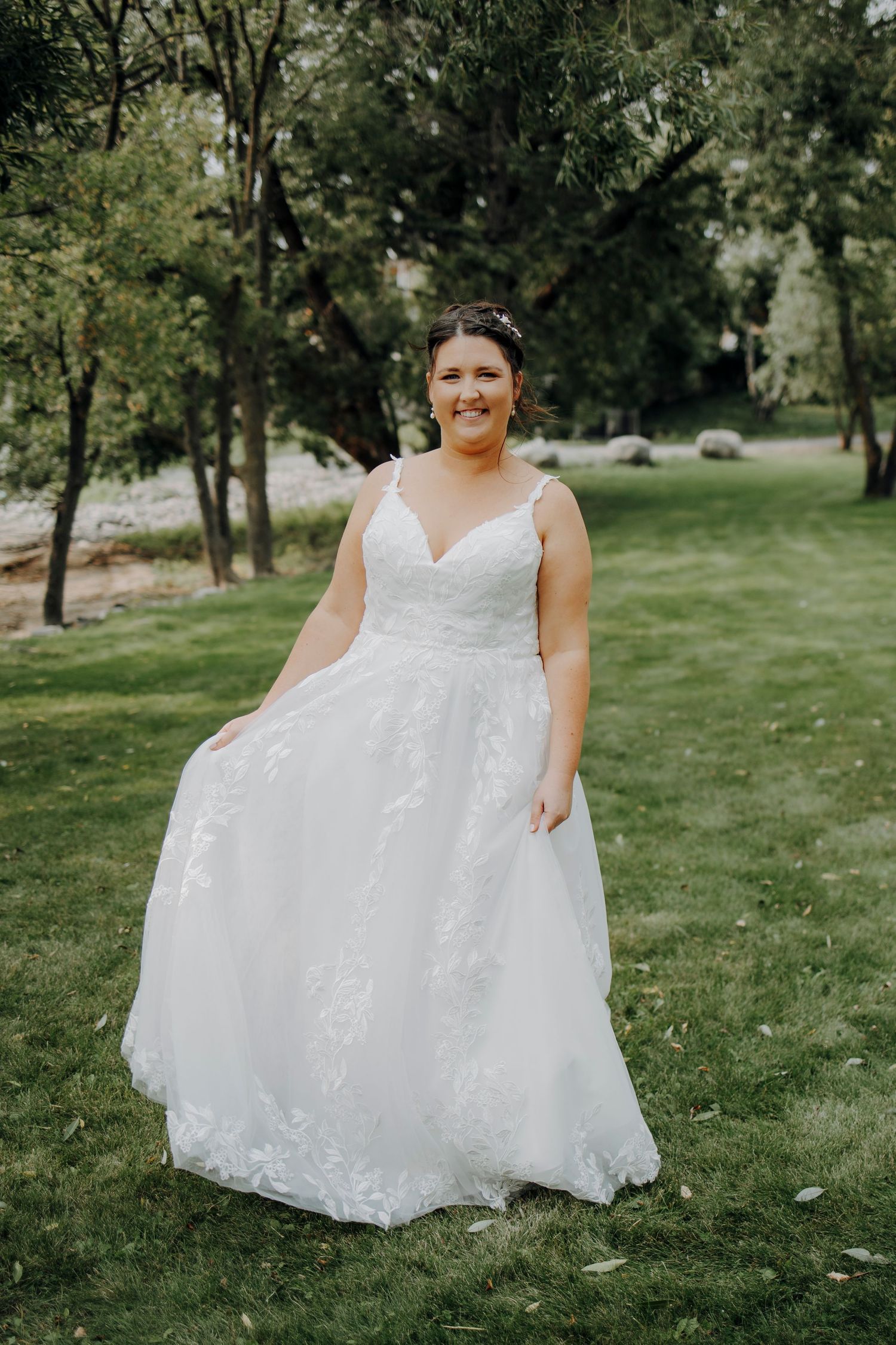 A beautiful white wedding dress with lace details photographed outdoors on a sunny day.