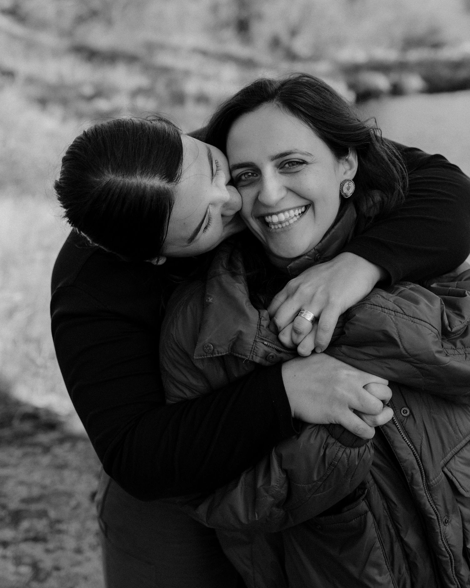 Black and white photo series showing affectionate couple sharing playful and intimate moments outdoors.