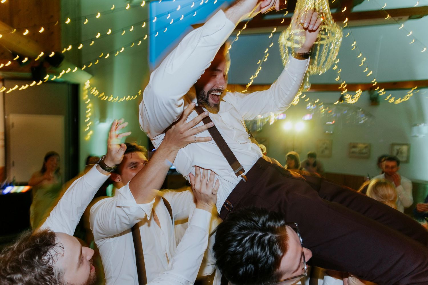 Wedding reception celebration with twinkle lights and dancing guests.